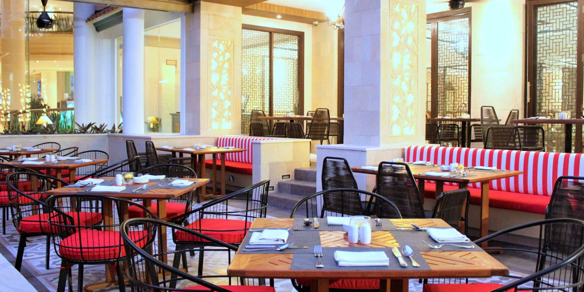 tables in a restaurant with red and white striped chairs