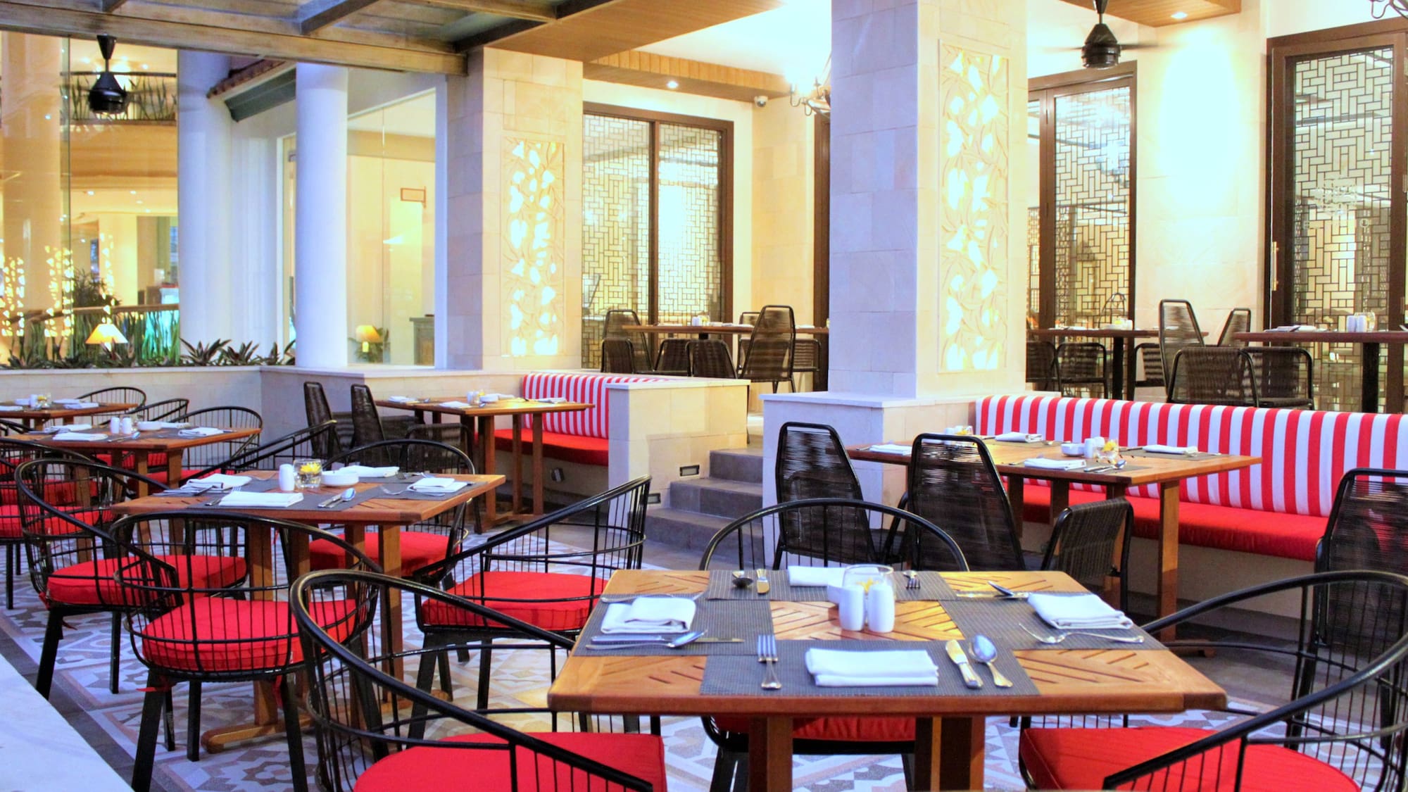 tables in a restaurant with red and white striped chairs