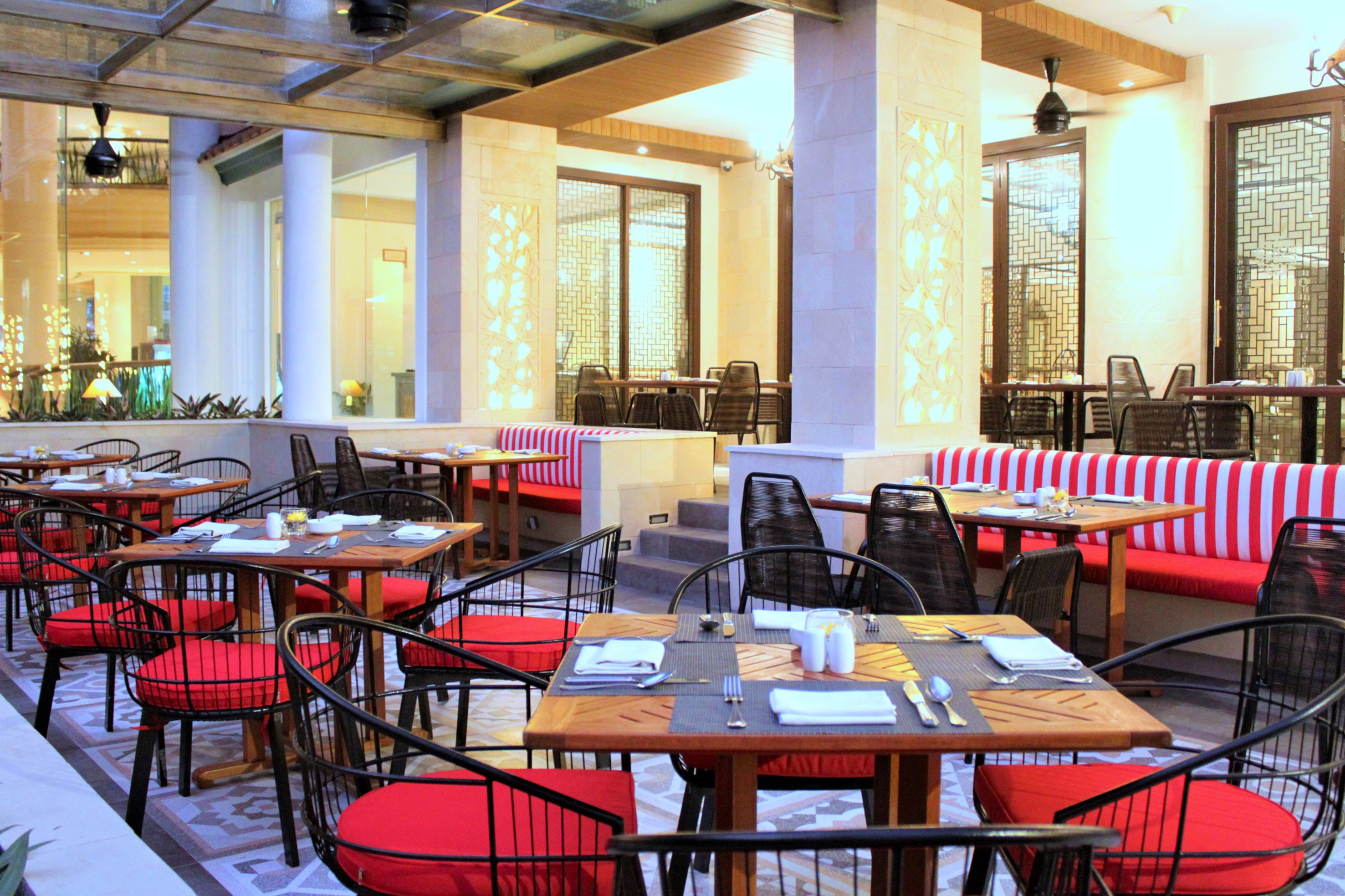 tables in a restaurant with red and white striped chairs