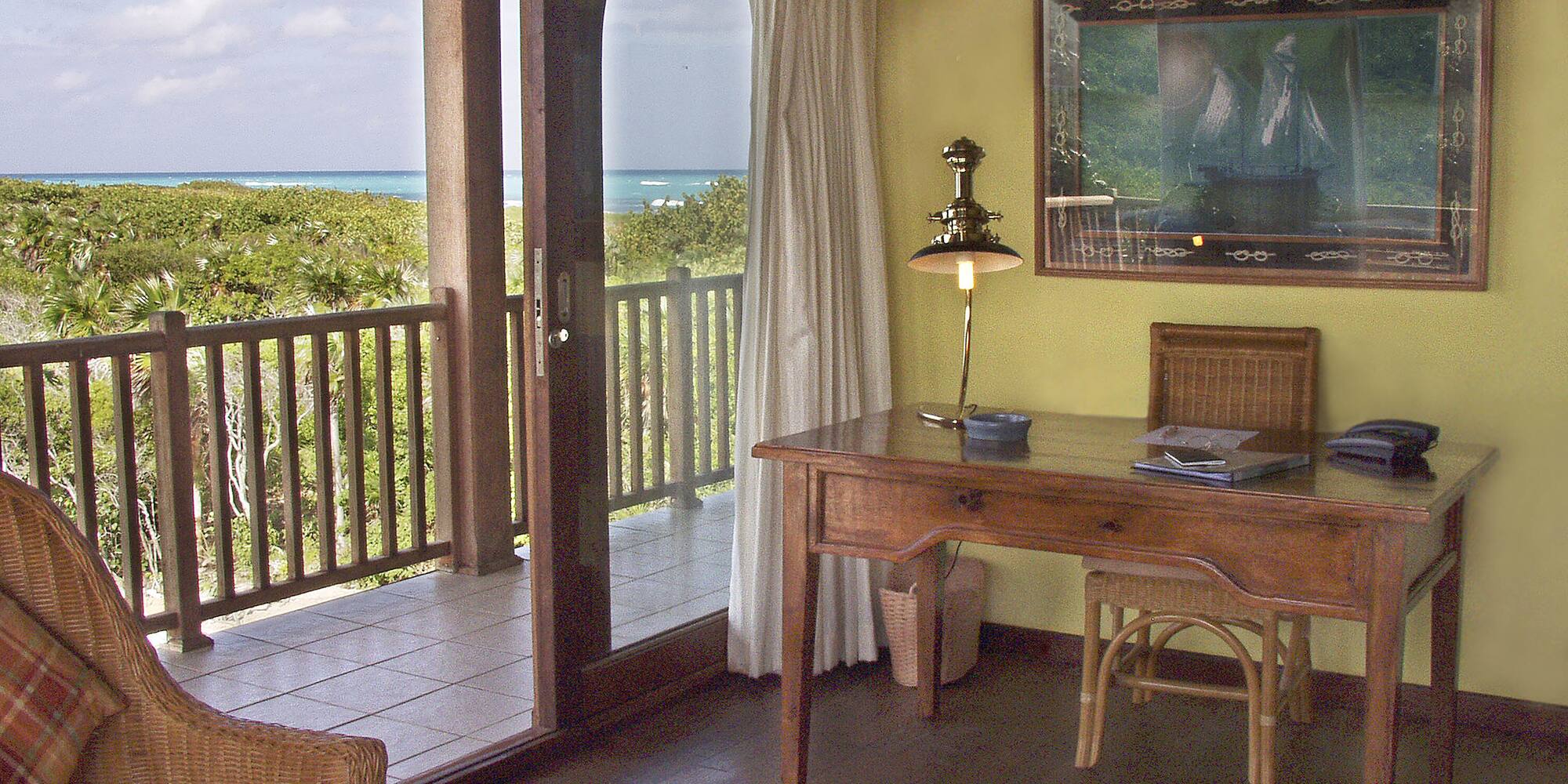 a desk and chair in a room with a view of the ocean