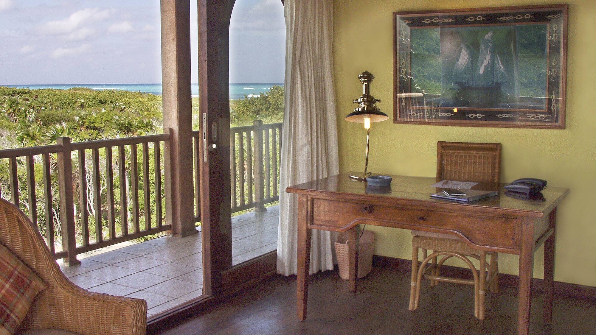 a desk and chair in a room with a view of the ocean