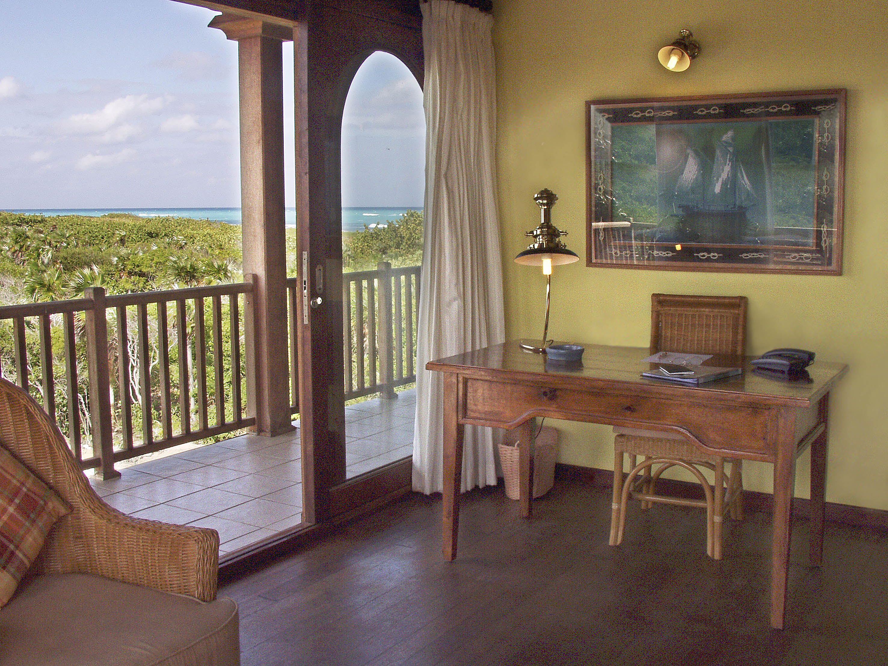 a desk and chair in a room with a view of the ocean