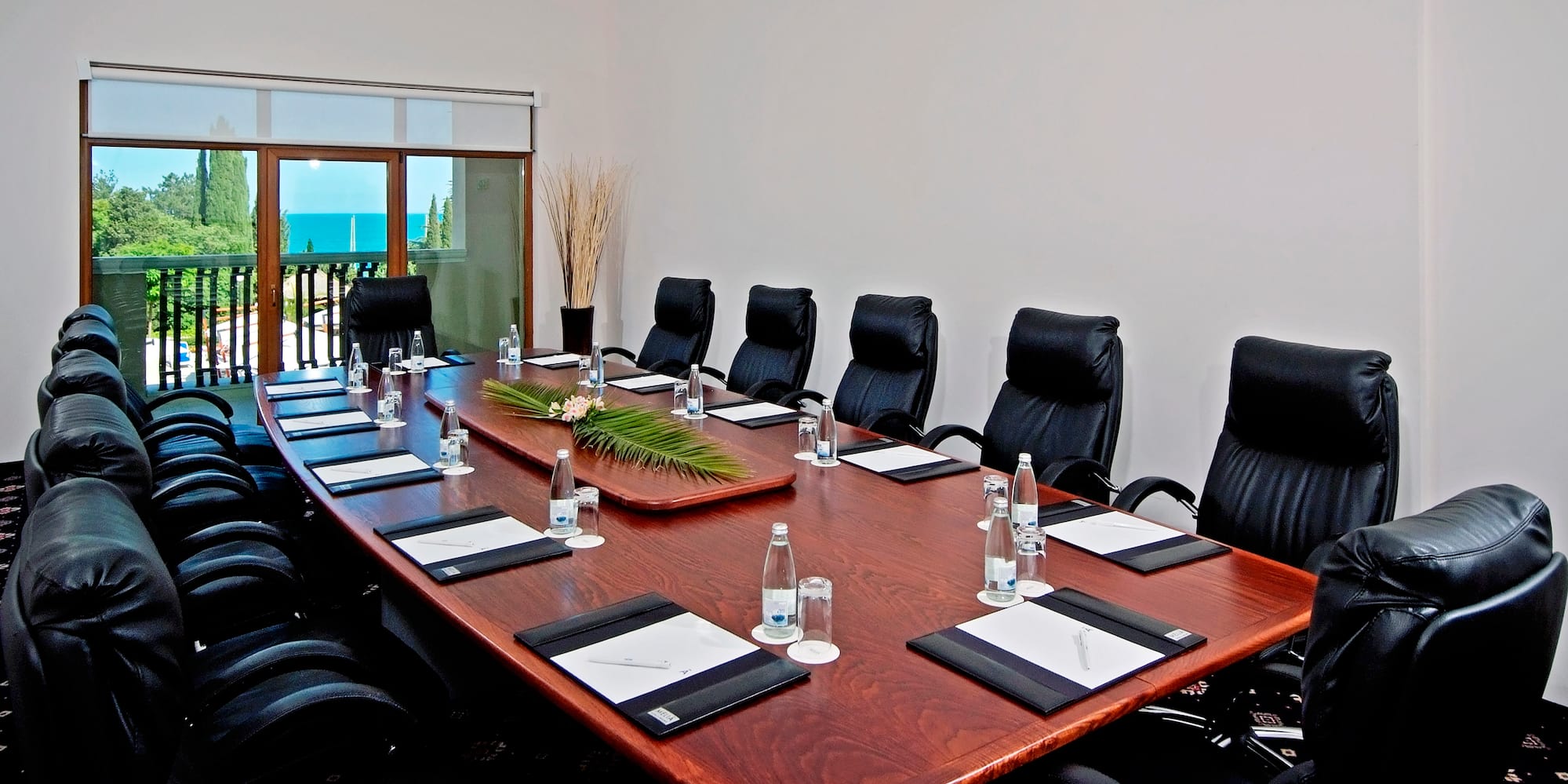 a conference table with chairs and a plant on top