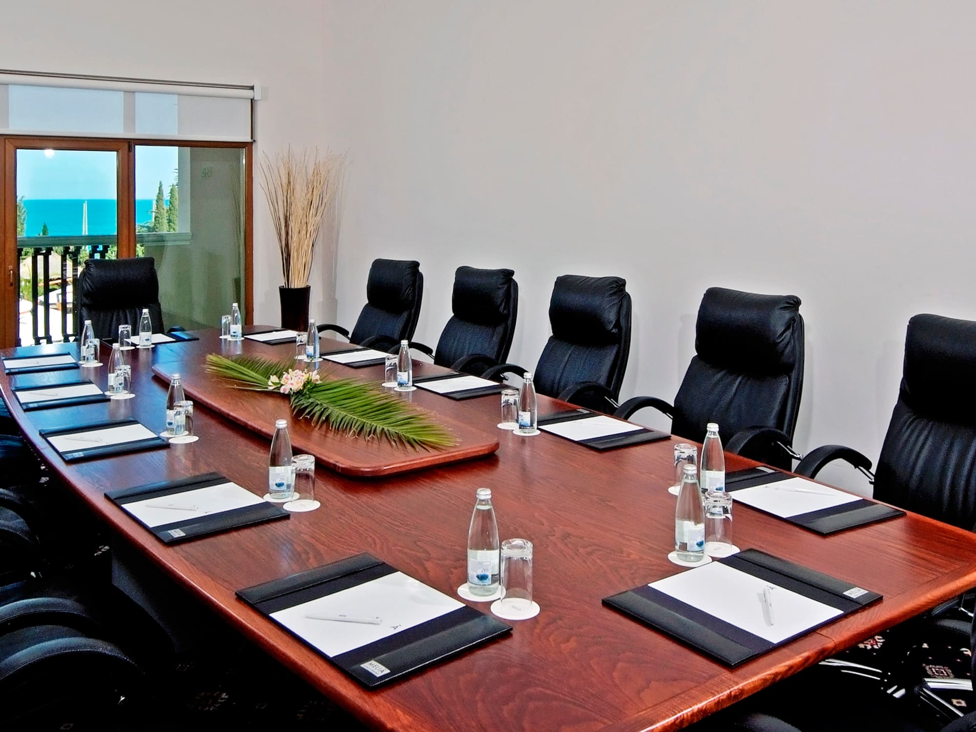 a conference table with chairs and a plant on top