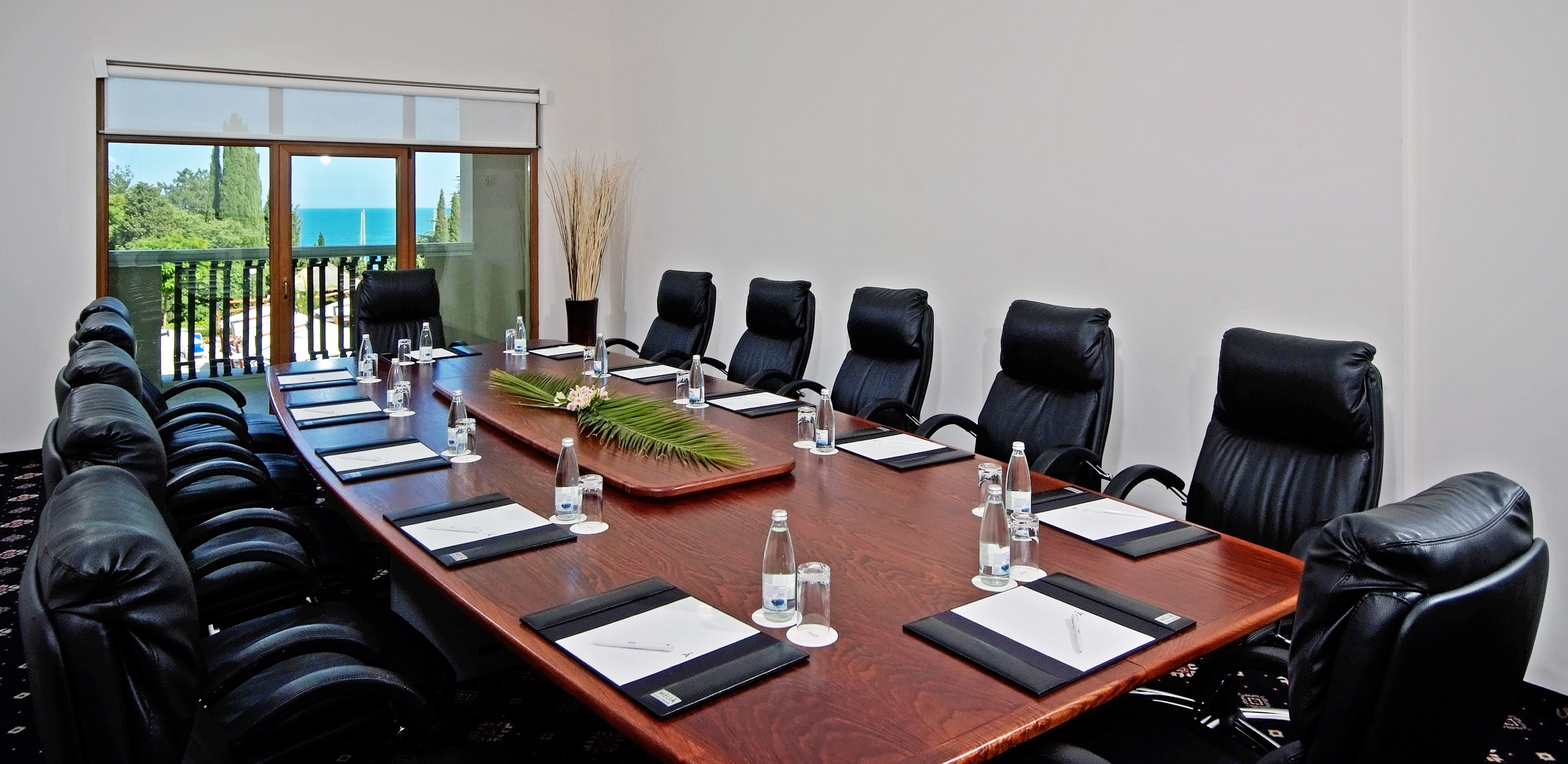 a conference table with chairs and a plant on top