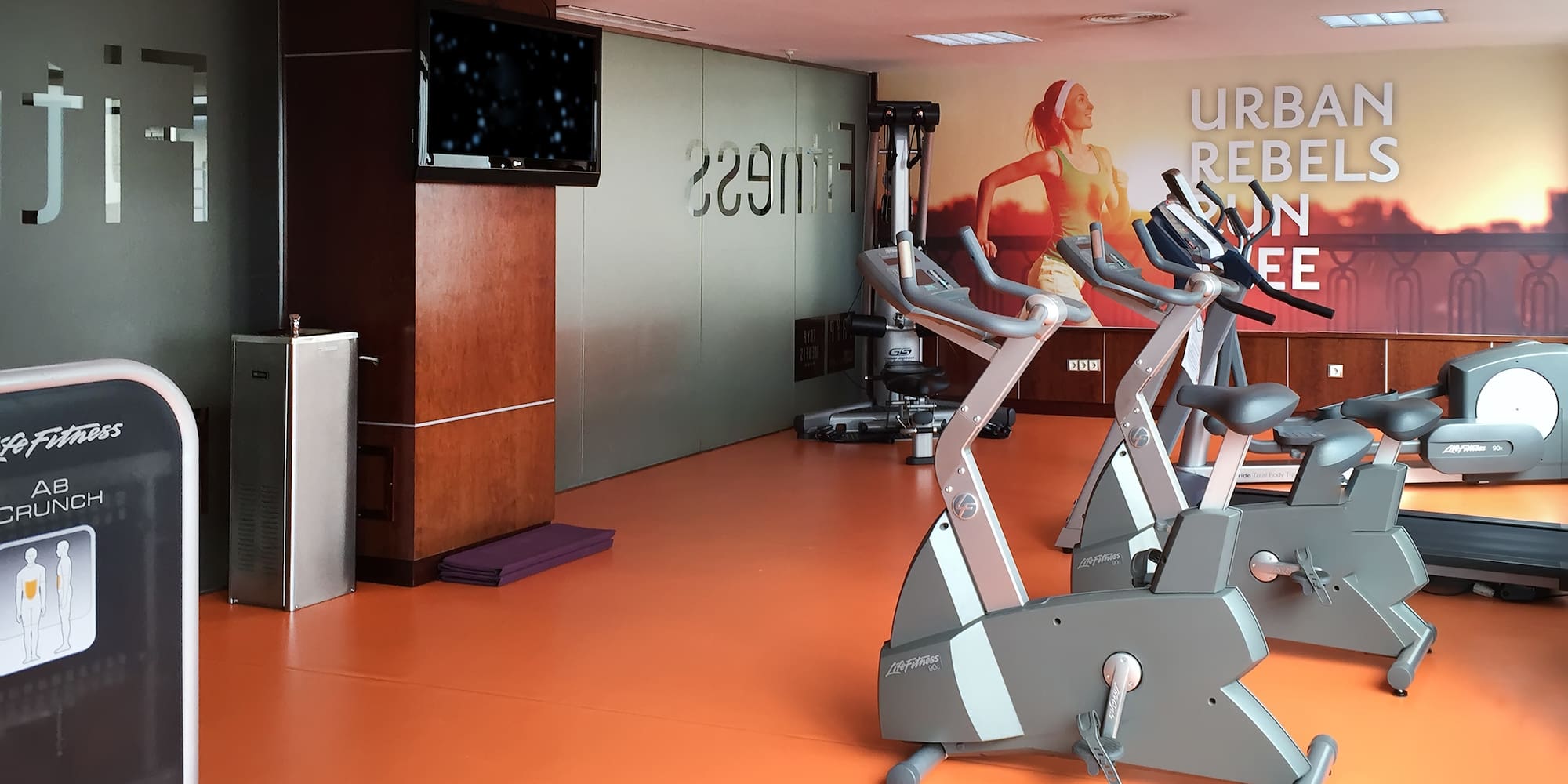 a room with exercise bikes and a tv