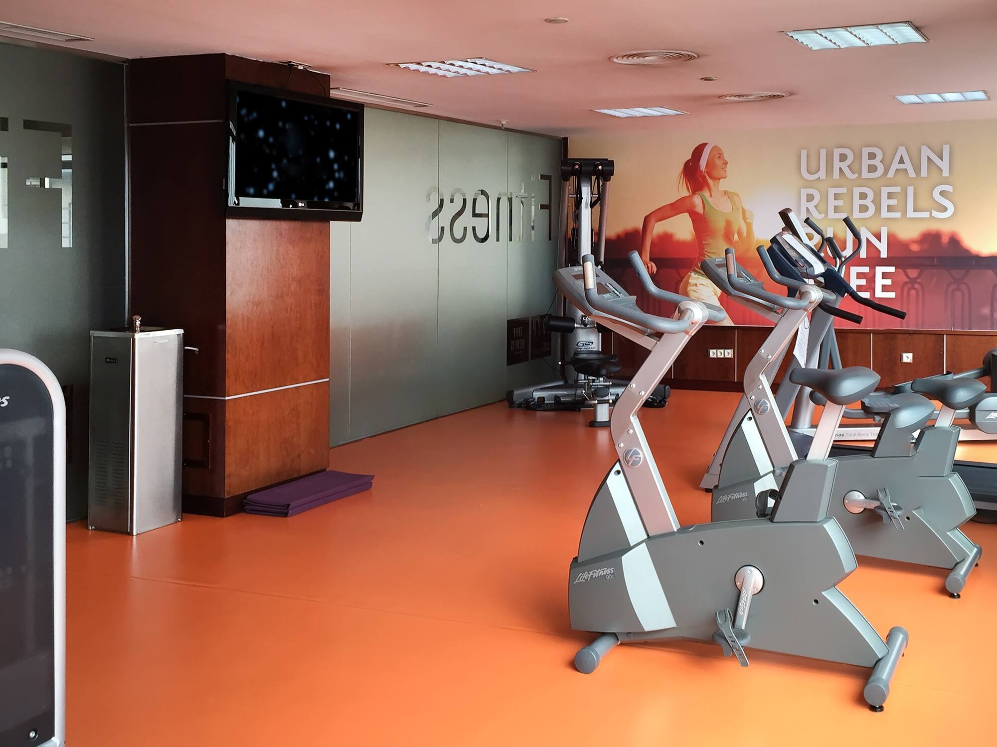 a room with exercise bikes and a tv