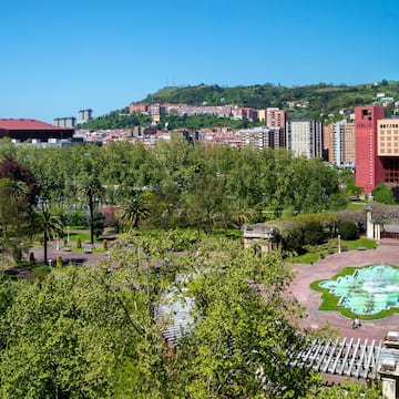 a park with trees and buildings in the background