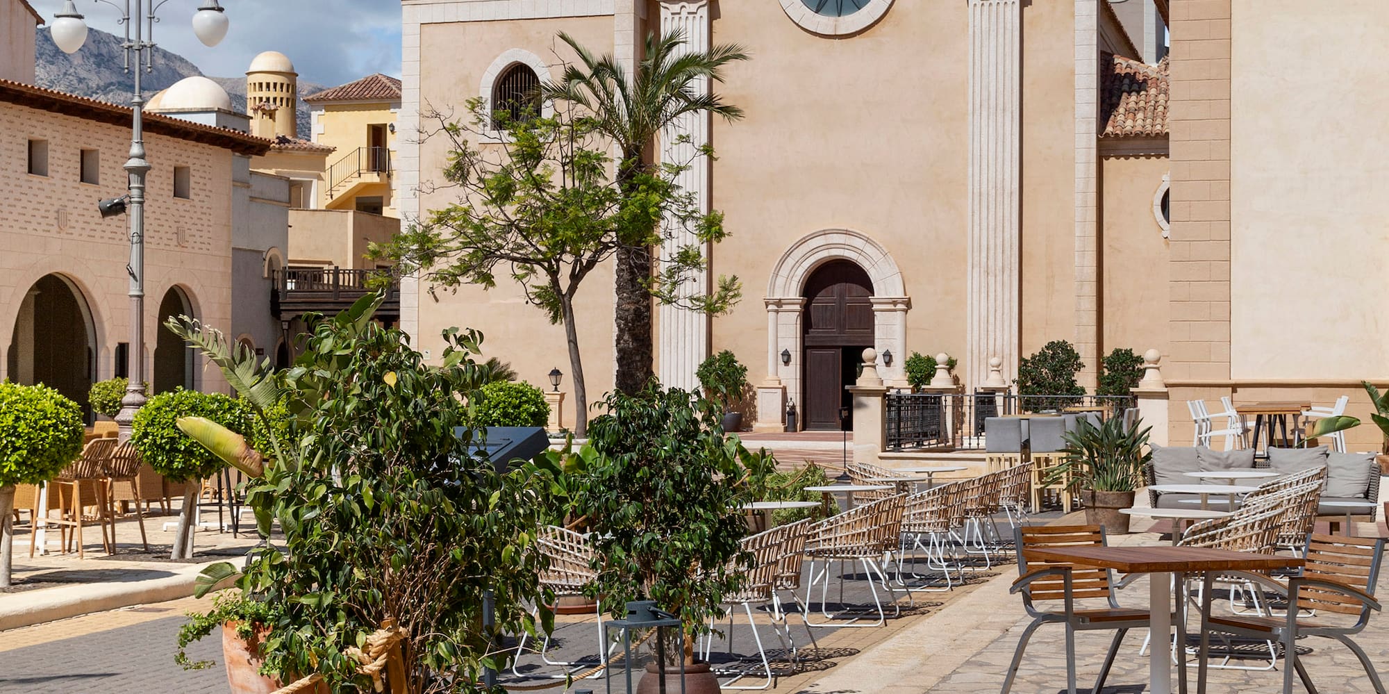 a building with a clock tower and tables and chairs