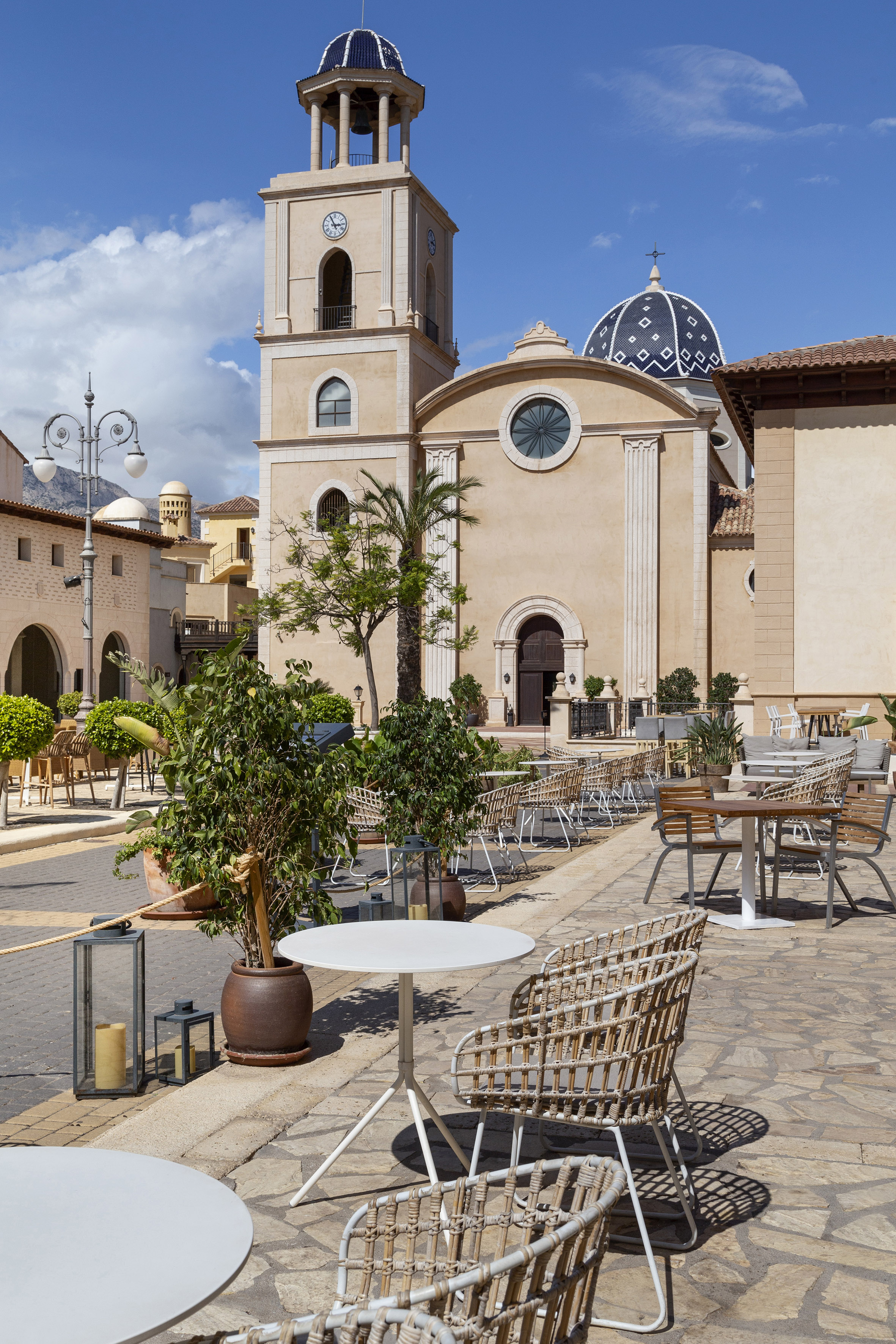 a building with a clock tower and tables and chairs