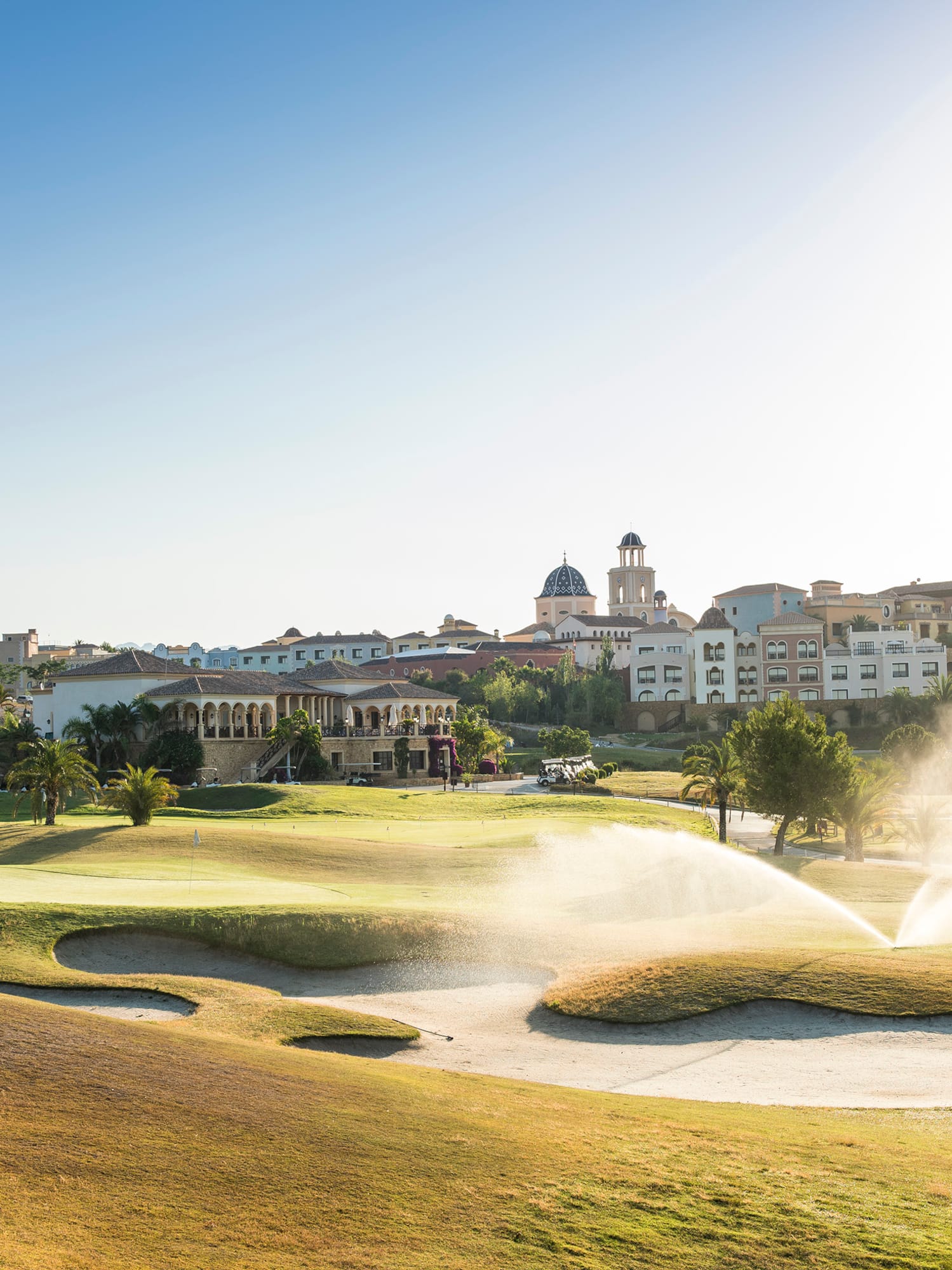 a water sprinklers spraying water on a golf course