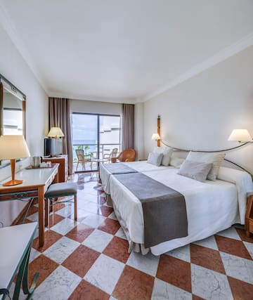 a room with a bed and a table and chairs