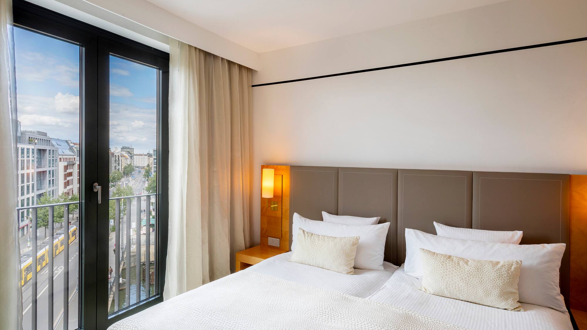 a bed with a door open to a balcony