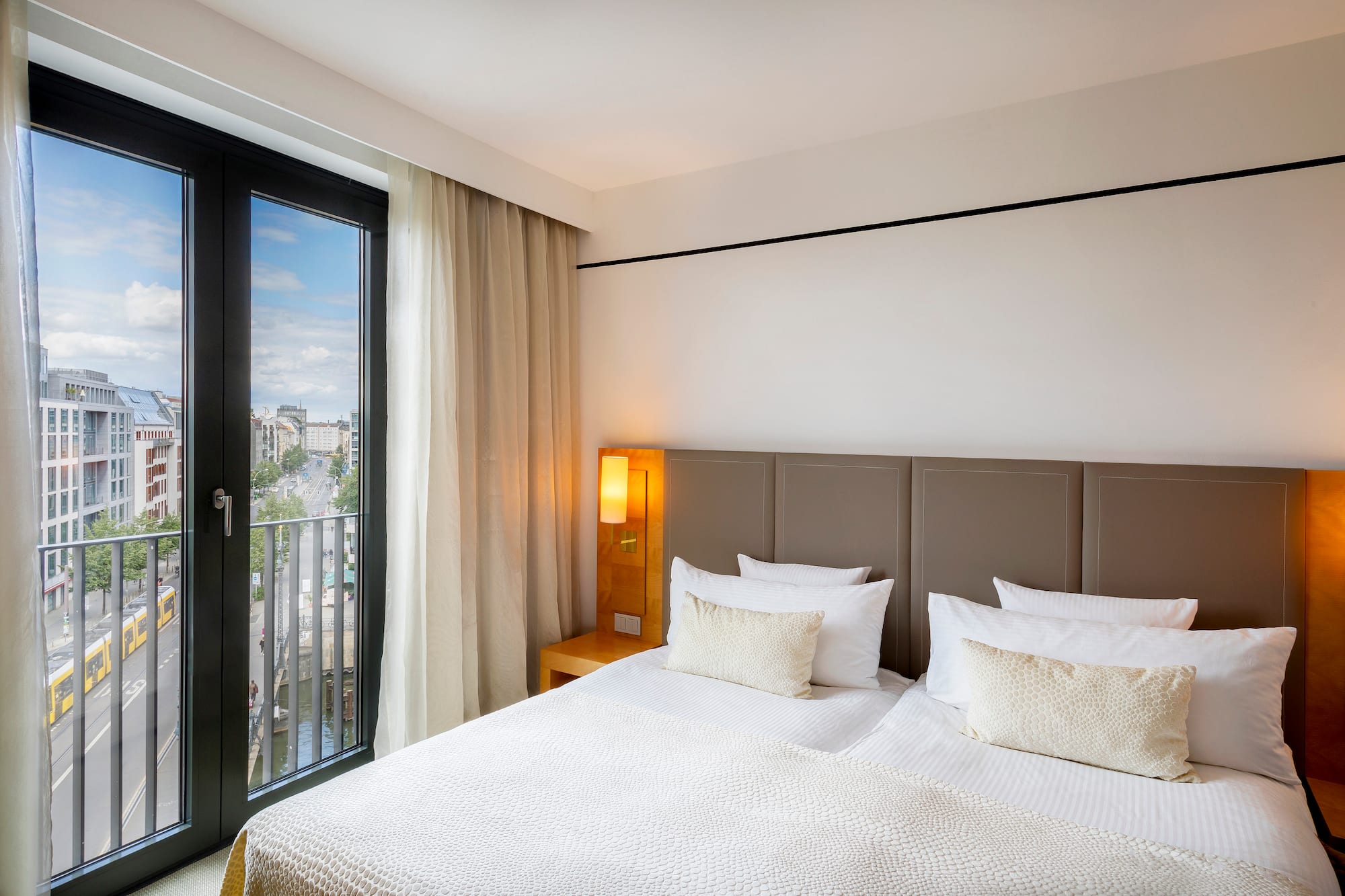 a bed with a door open to a balcony