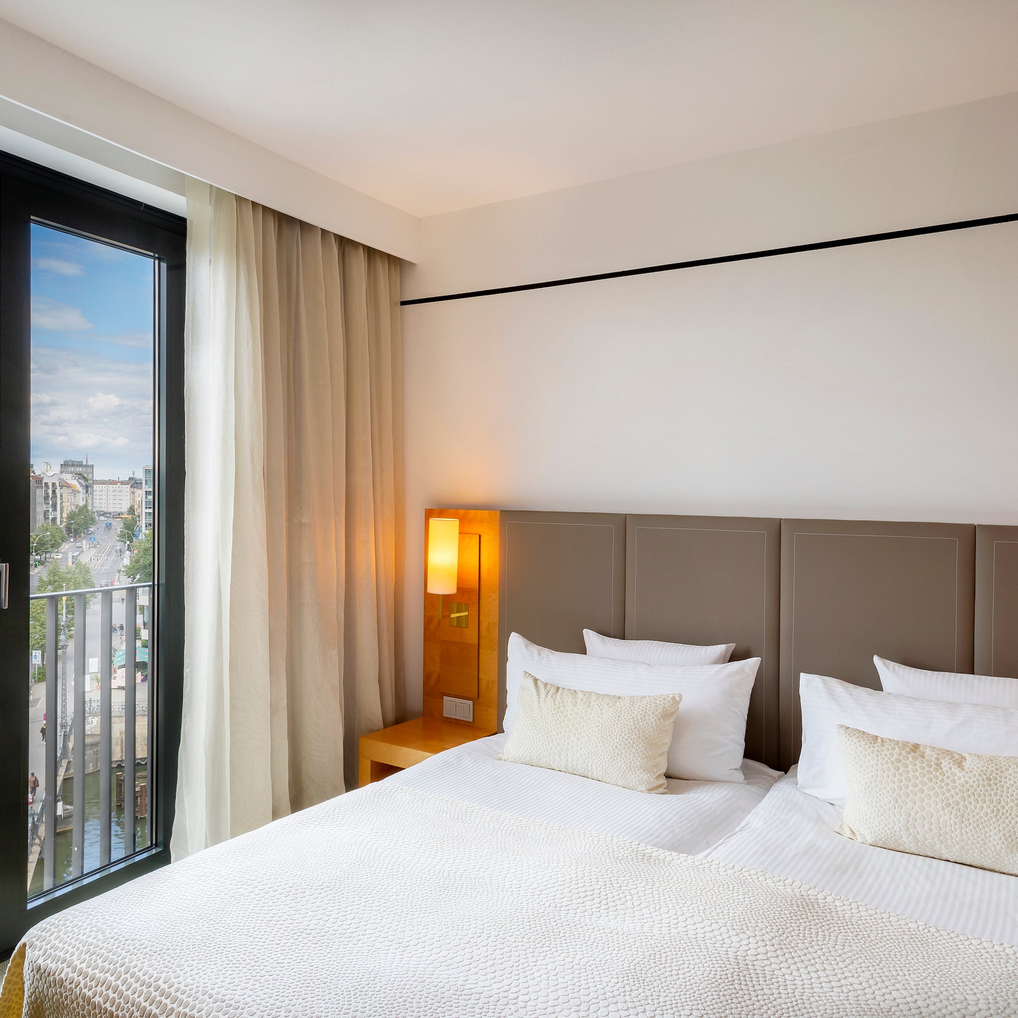 a bed with a door open to a balcony