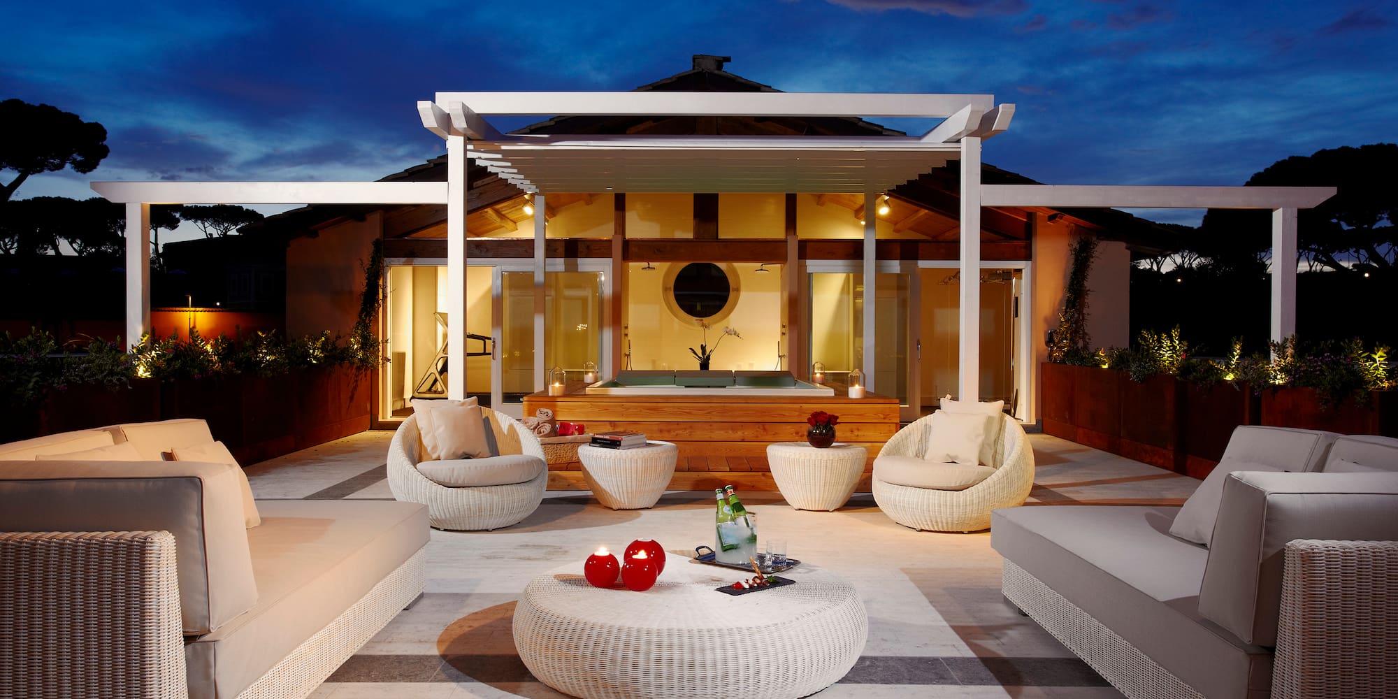 a patio with a hot tub and chairs