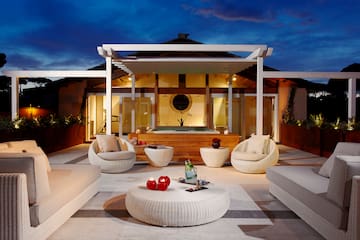 a patio with a hot tub and chairs