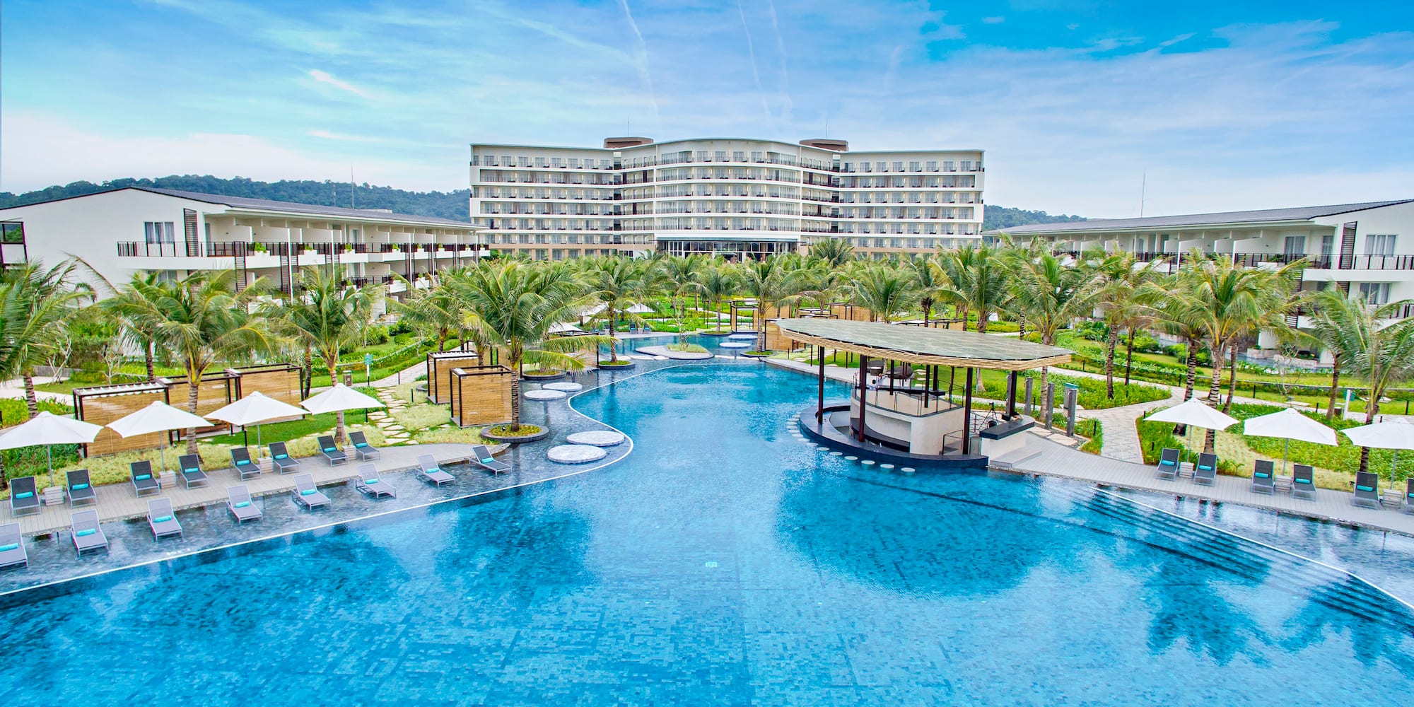 a pool with palm trees and a building in the background