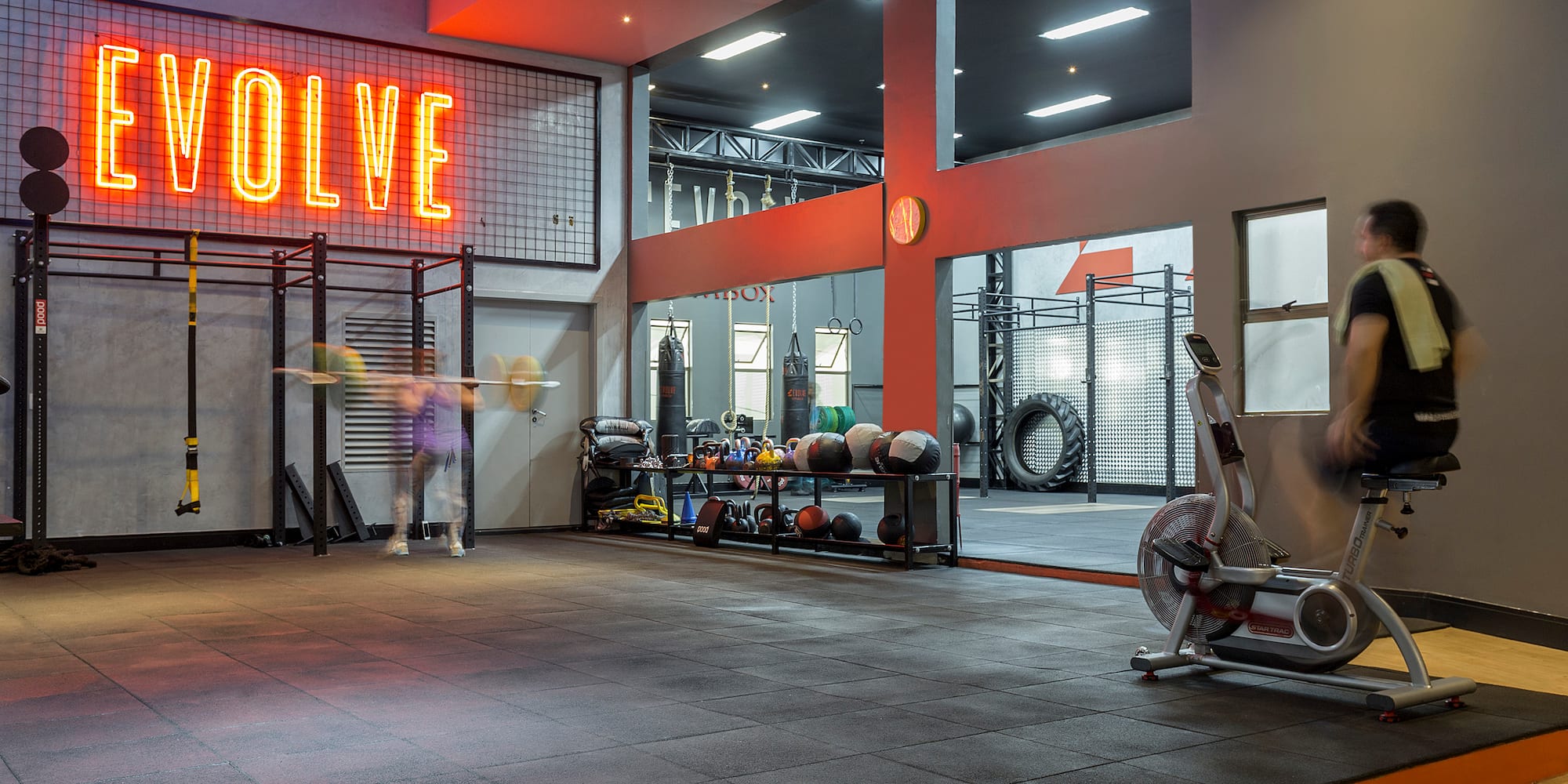 a gym with a gym equipment and a neon sign