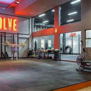 a gym with a gym equipment and a neon sign