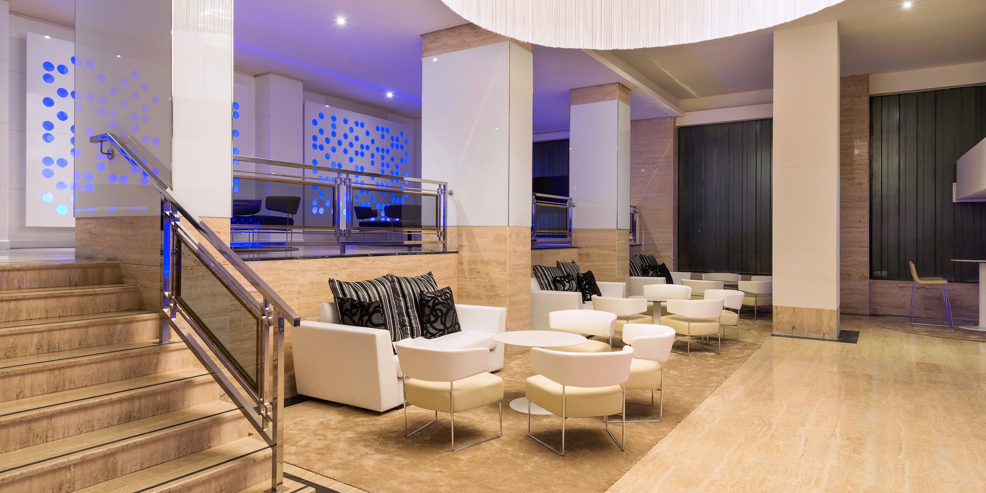 a room with white chairs and a staircase