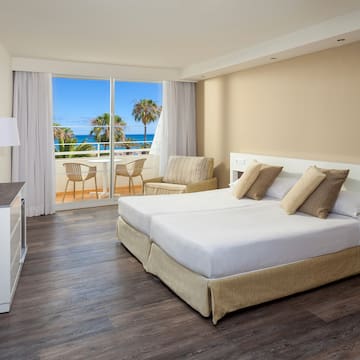 a hotel room with a view of the ocean and palm trees