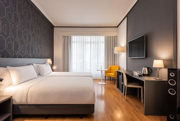 a room with a bed and a table and a tv