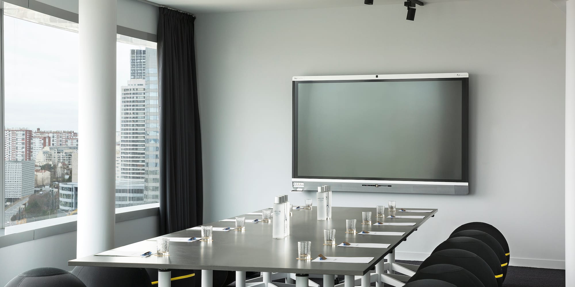 a room with a large screen and a table with chairs