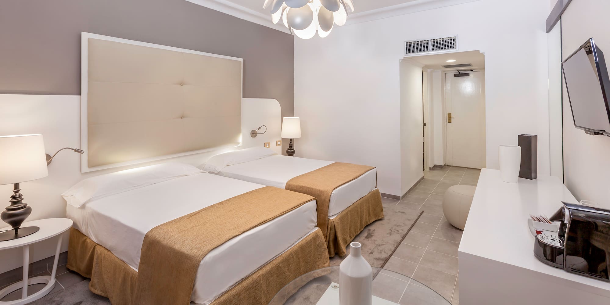 a room with two beds and a lamp