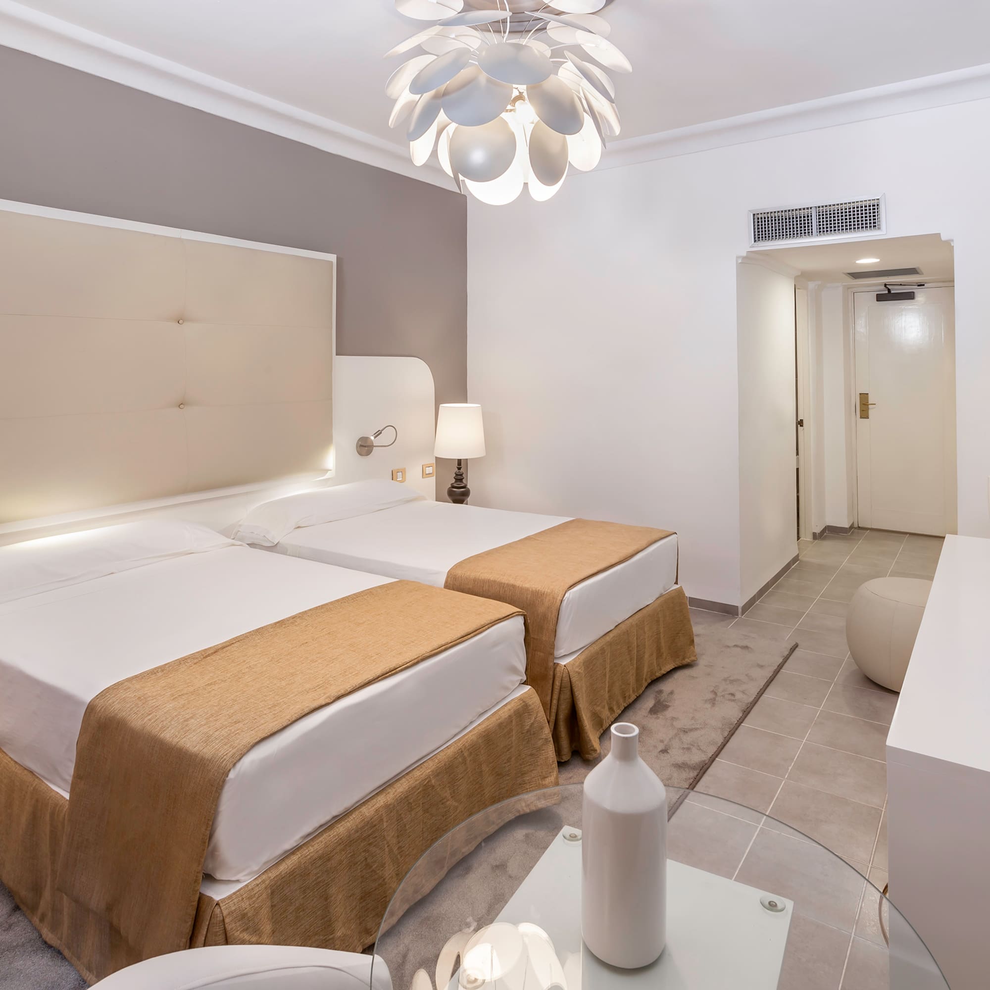 a room with two beds and a lamp