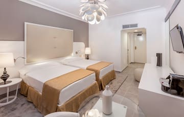 a room with two beds and a lamp