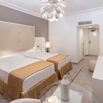 a room with two beds and a lamp