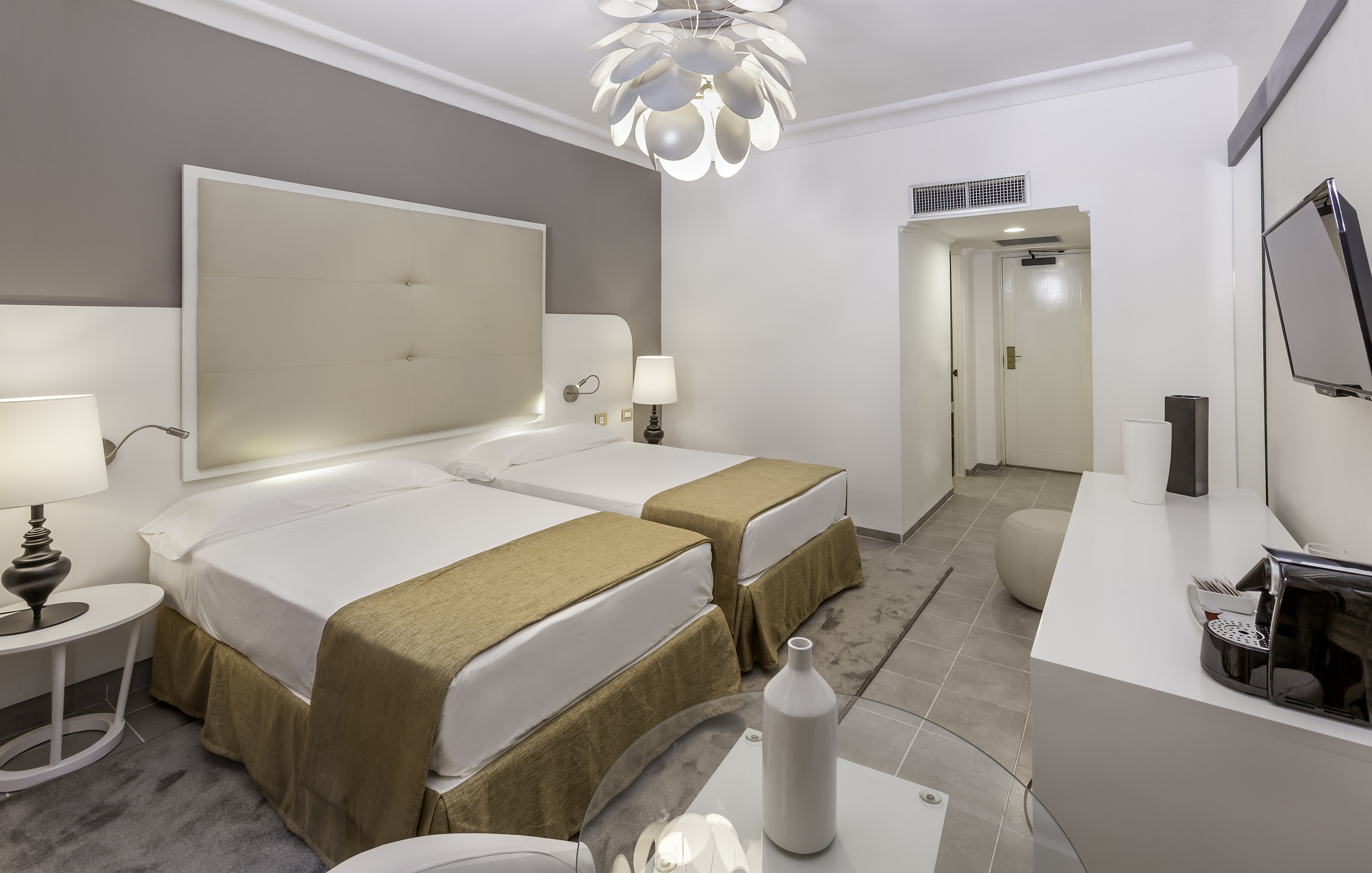 a room with two beds and a lamp