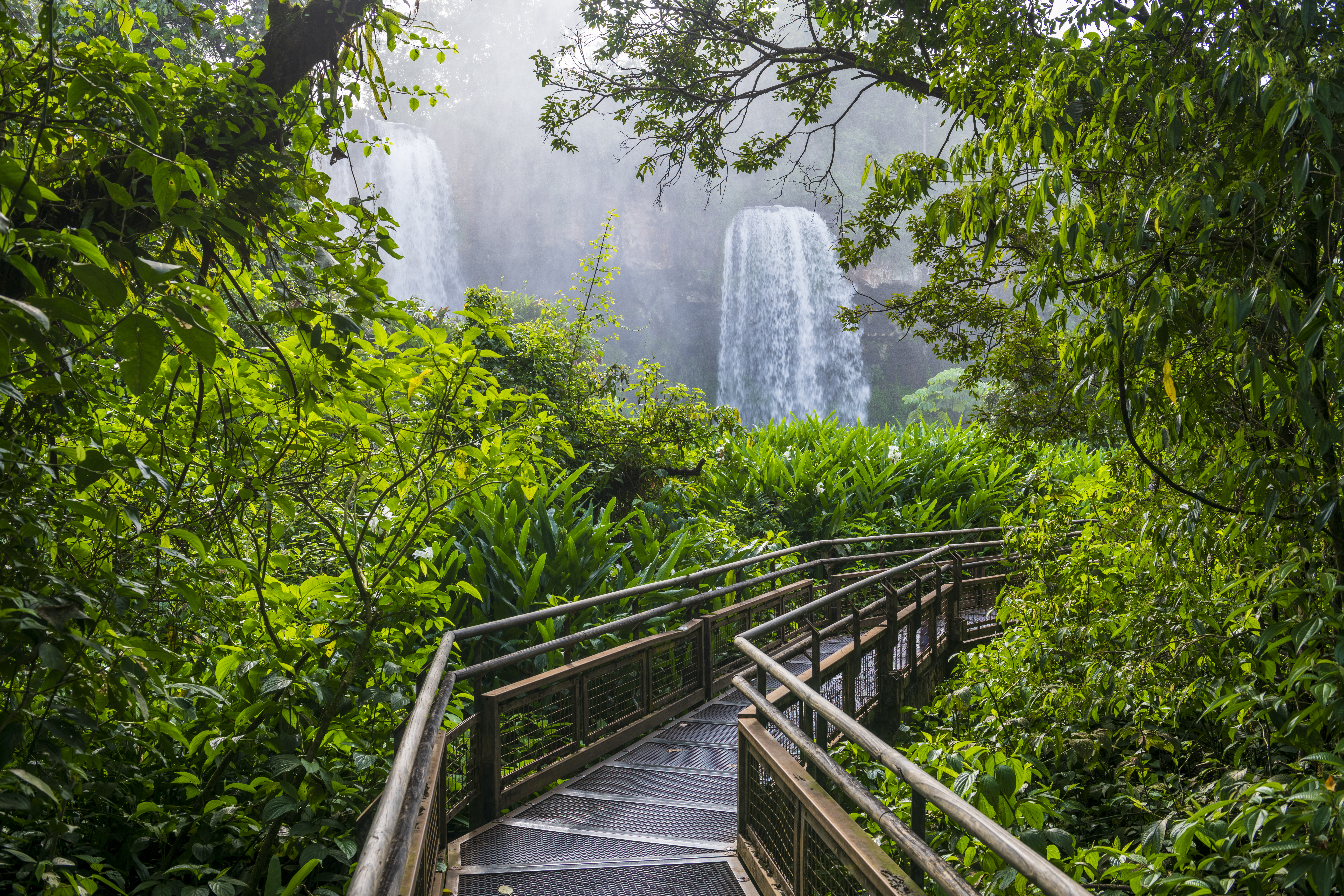 a walkway leading to a waterfall
