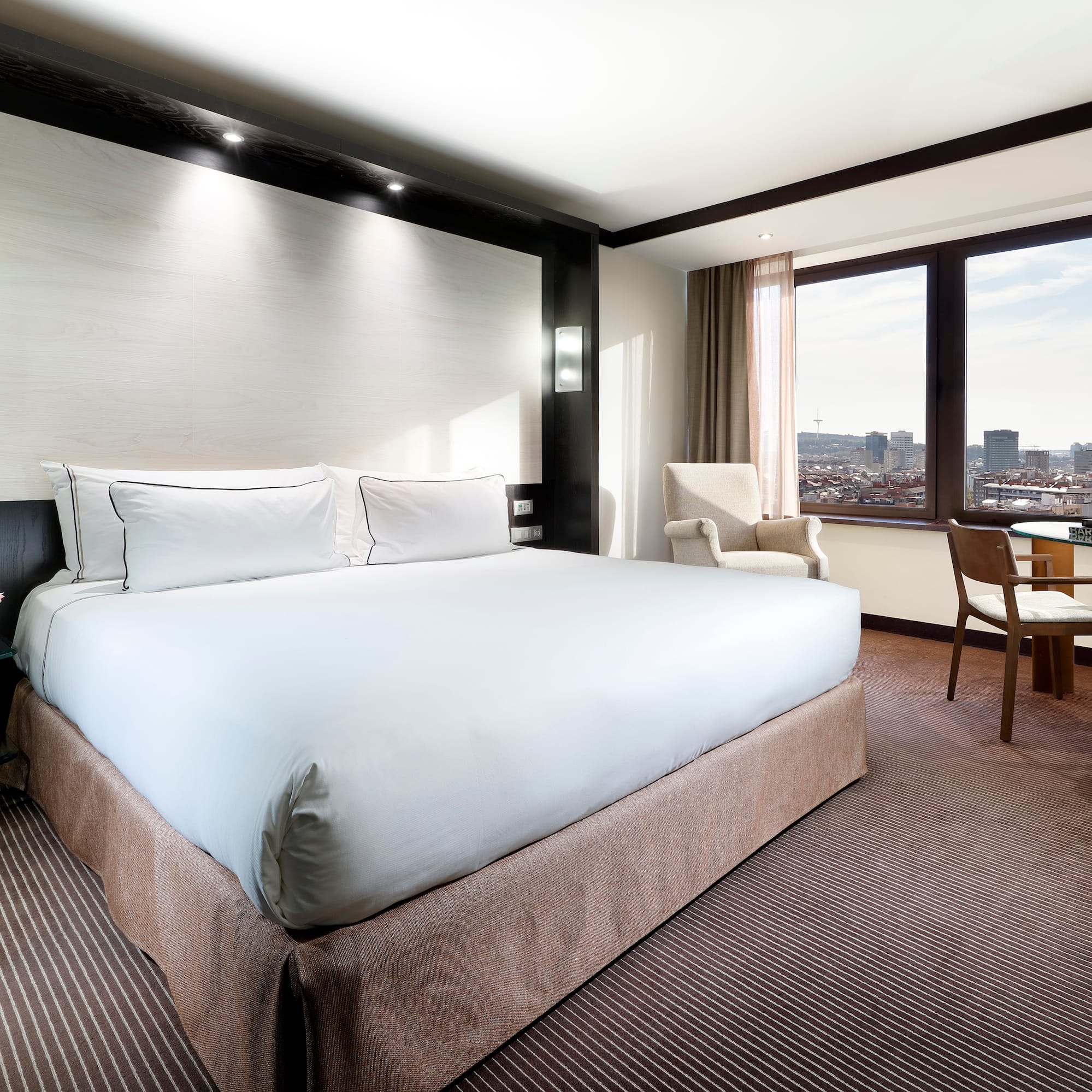 a hotel room with a large bed and chairs