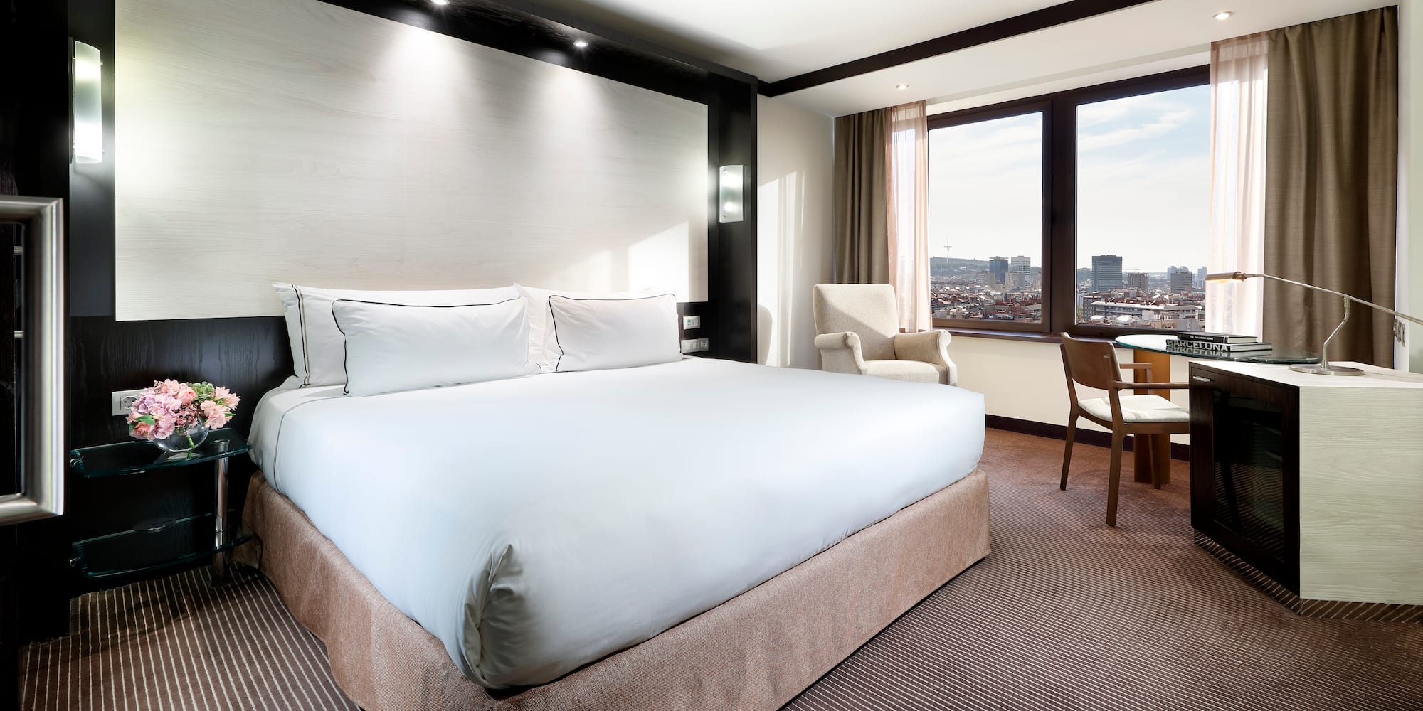 a hotel room with a large bed and chairs