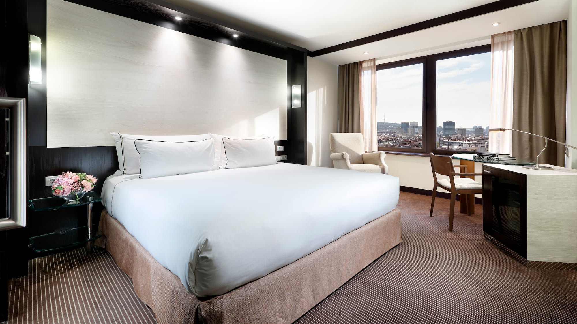 a hotel room with a large bed and chairs