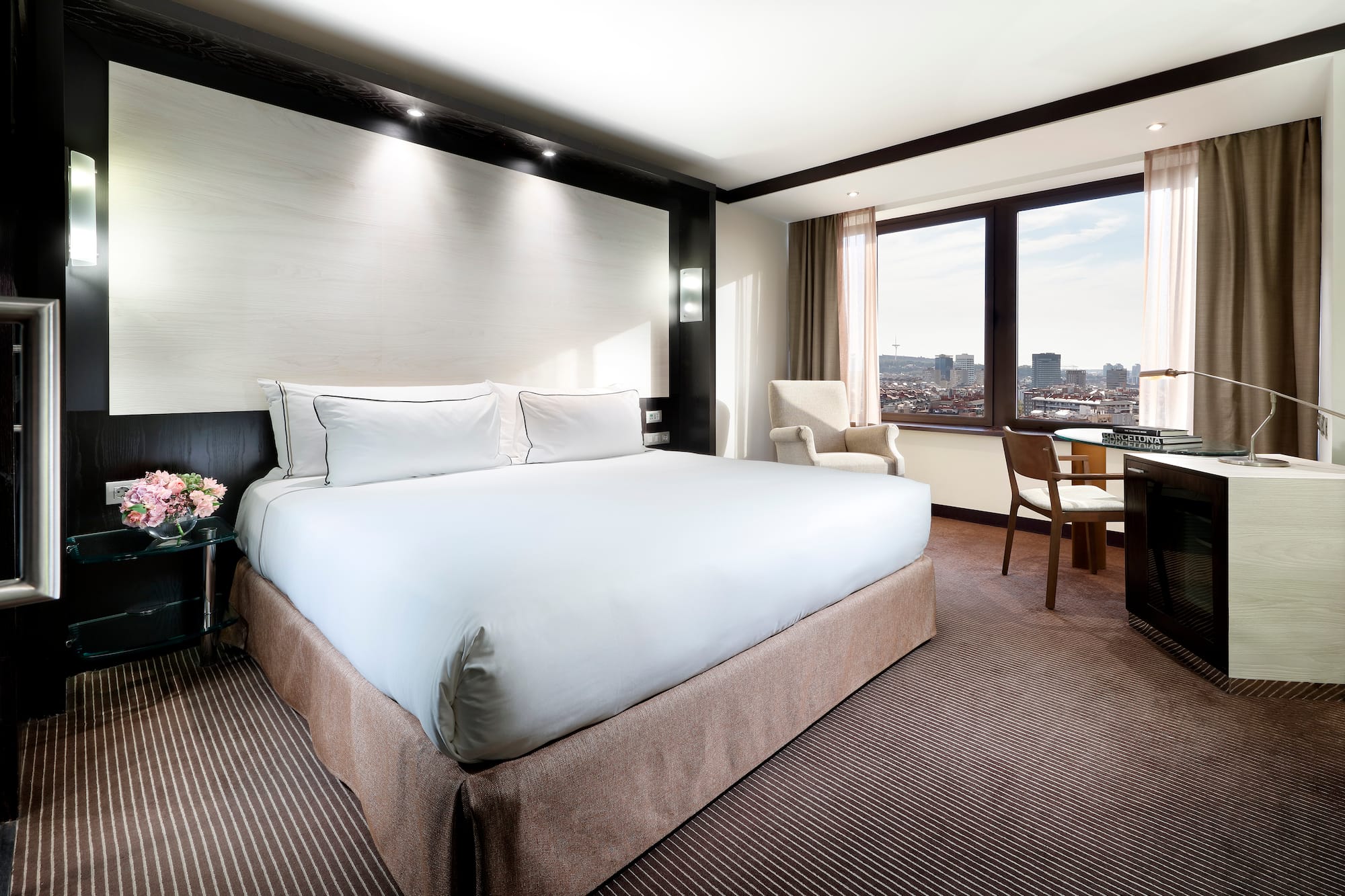 a hotel room with a large bed and chairs