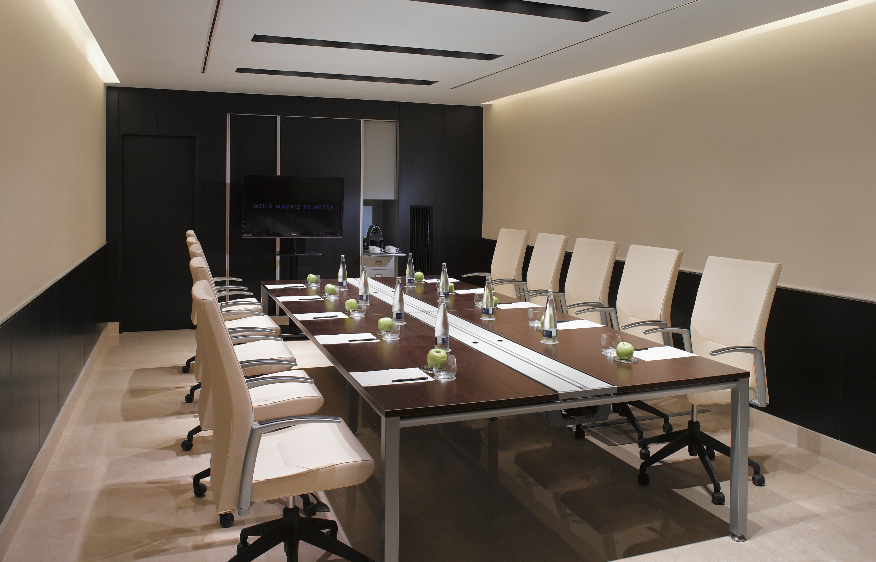 Melia Madrid Princesa conference room with dark table and cream chairs.