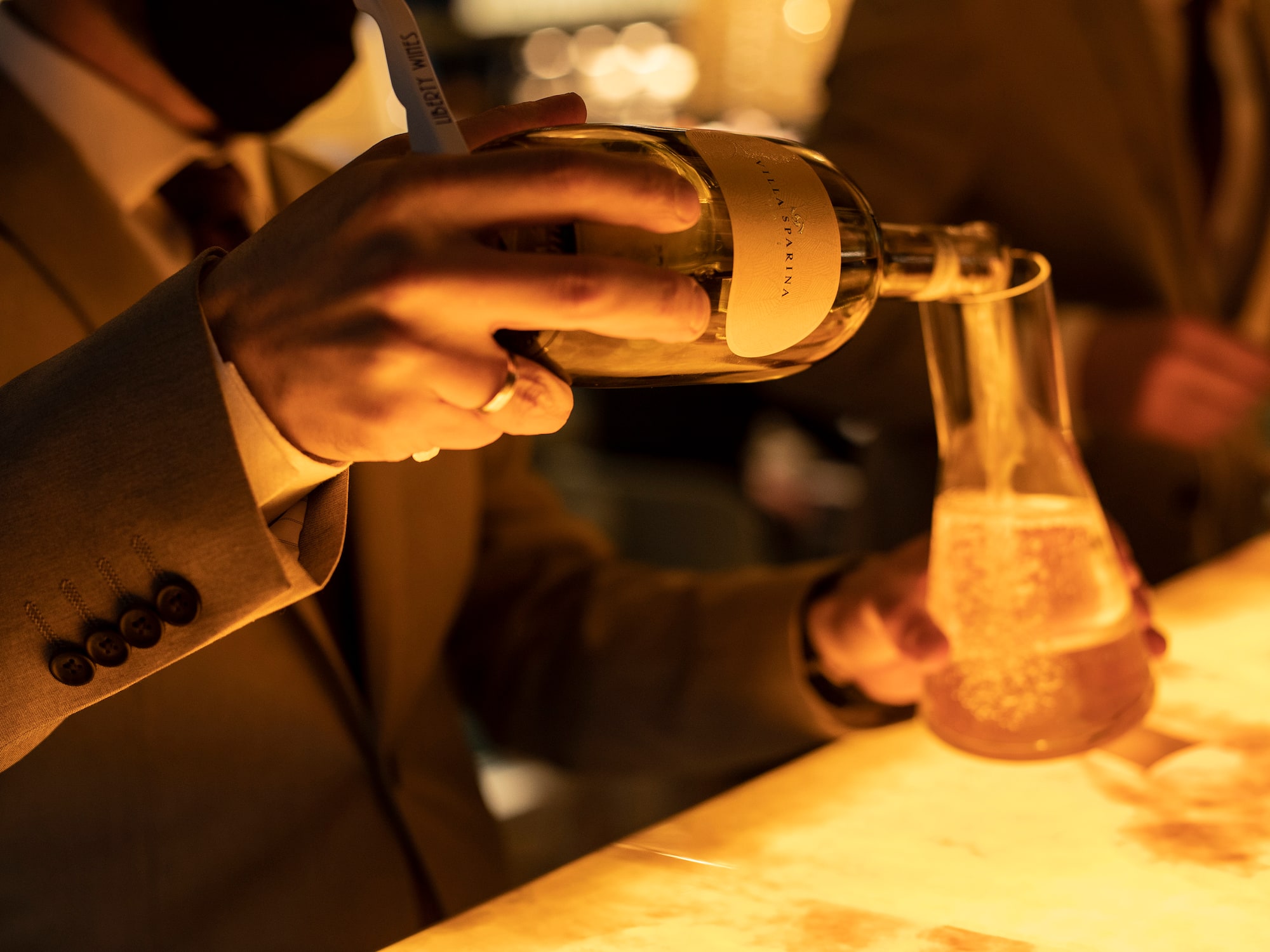 a person pouring liquid into a beaker