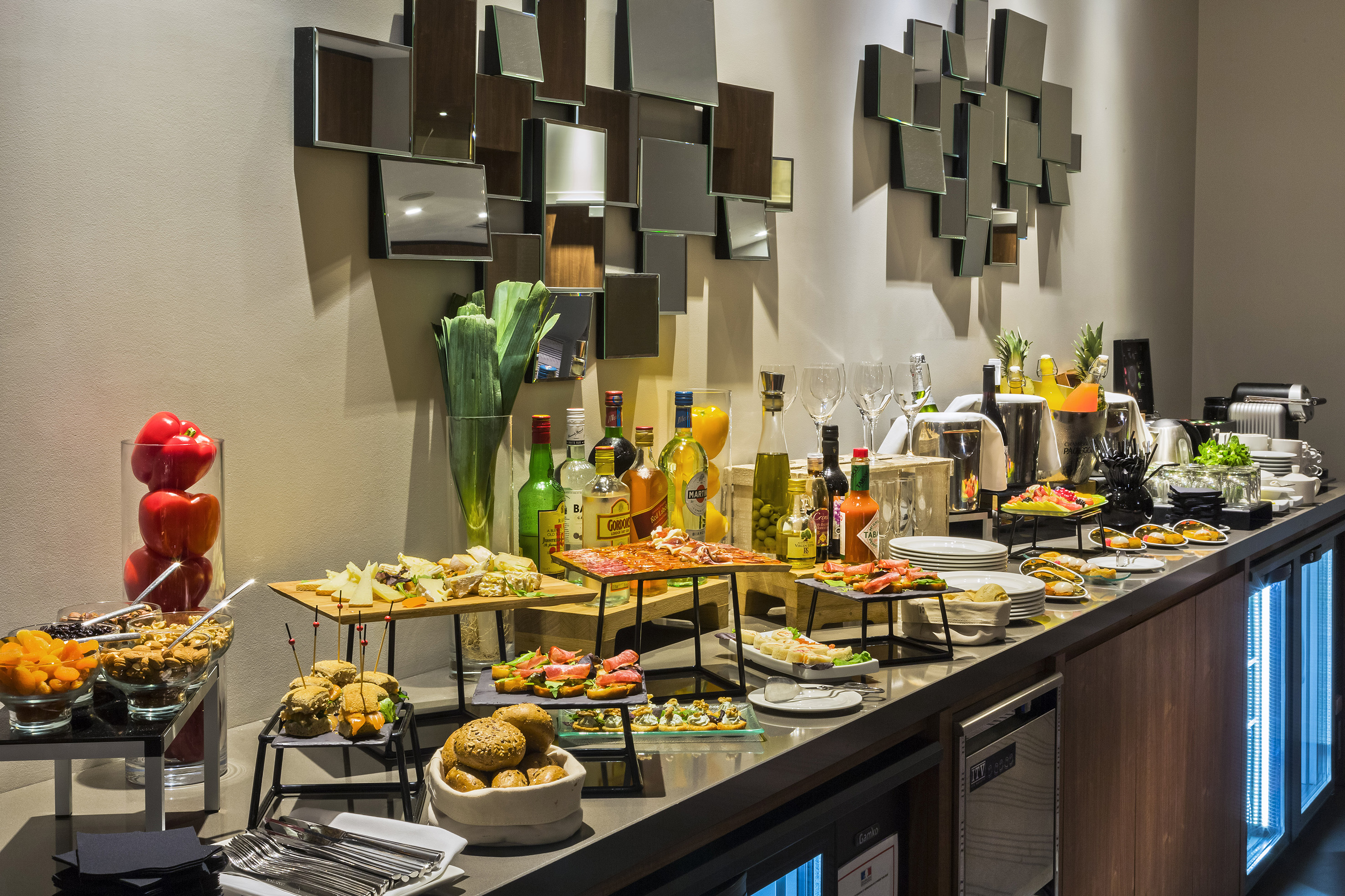 Hotel buffet spread with appetizers, cold cuts, cheeses, bread, and drinks.