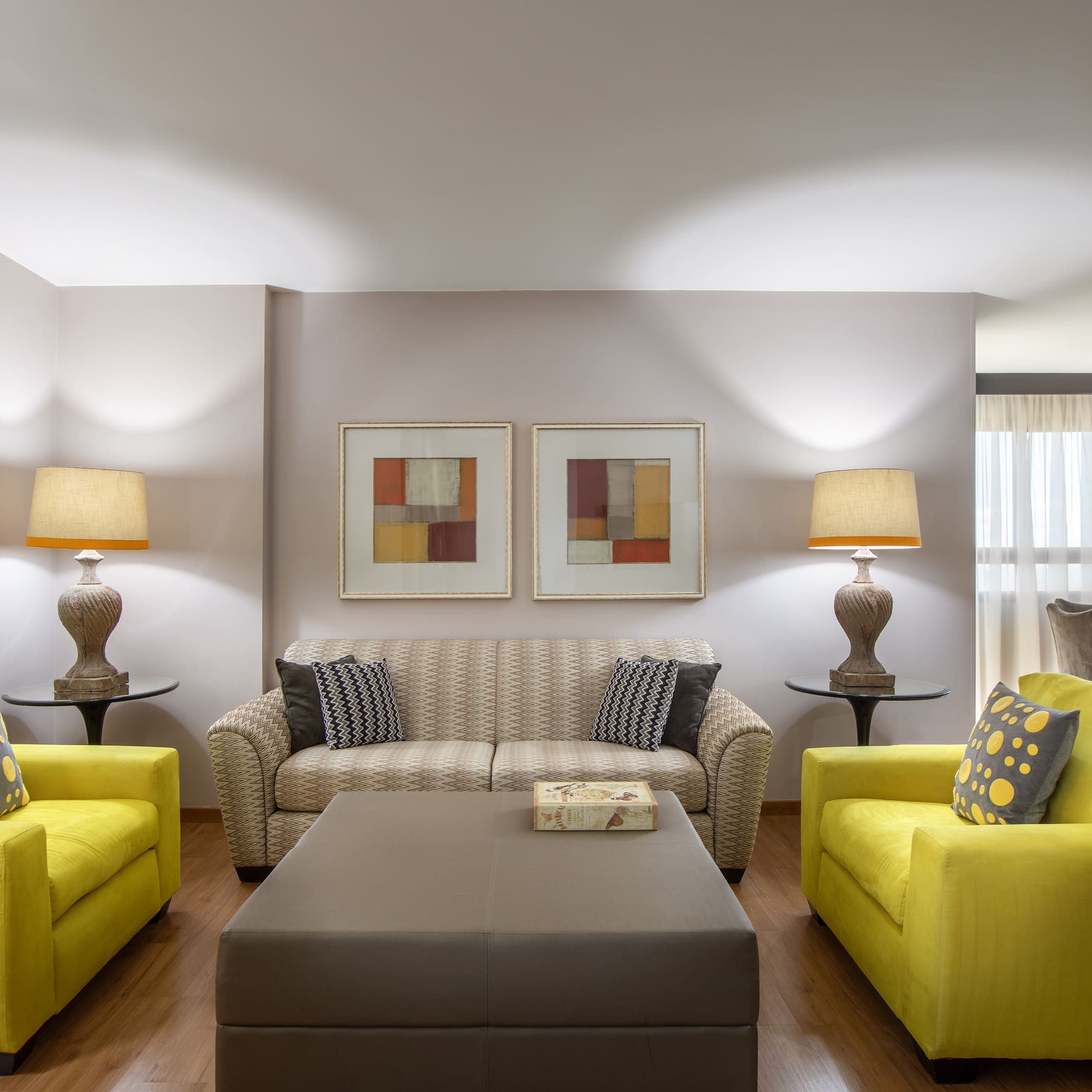 a living room with yellow couches and a coffee table