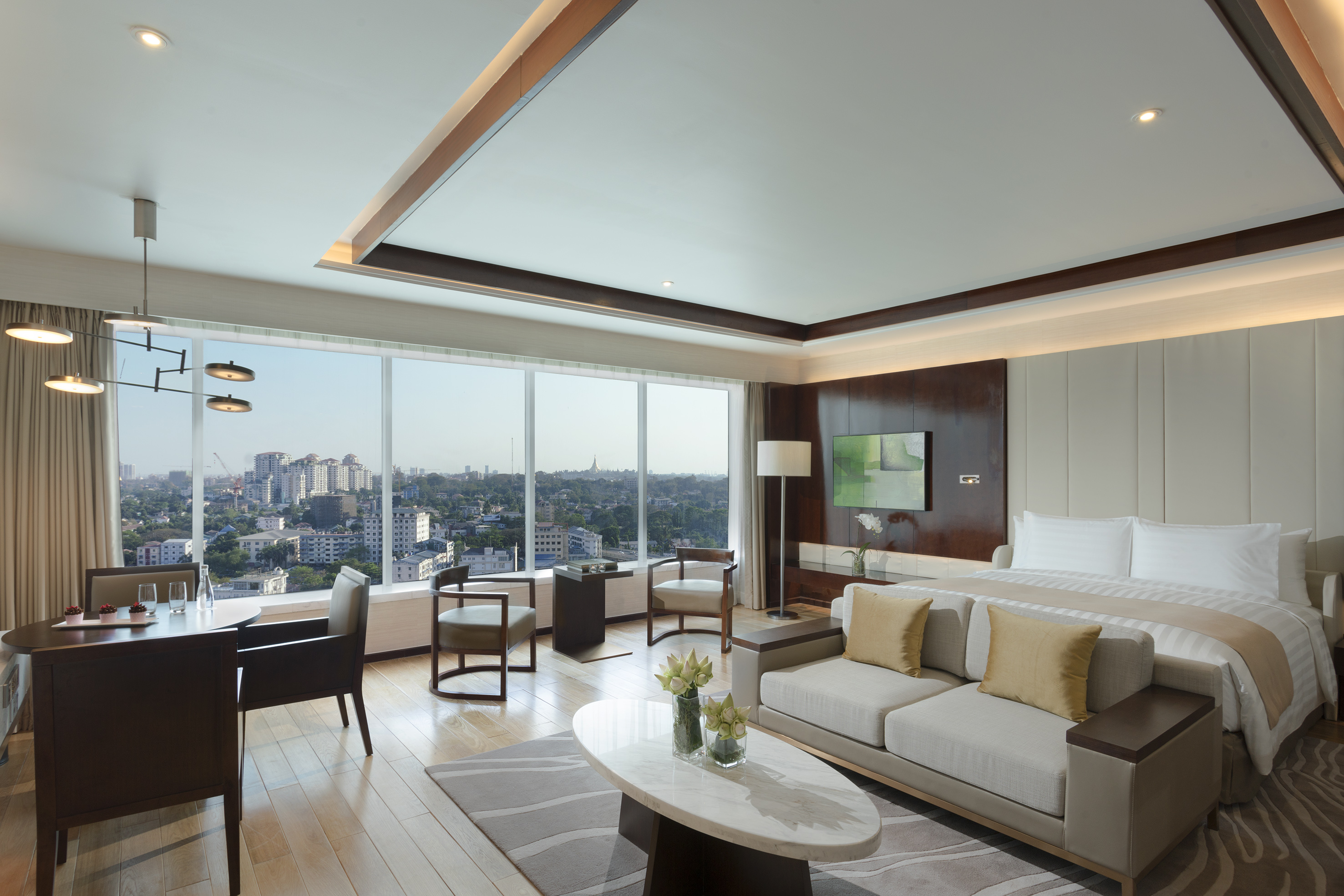 Modern hotel suite with city view, king bed, and stylish living area.