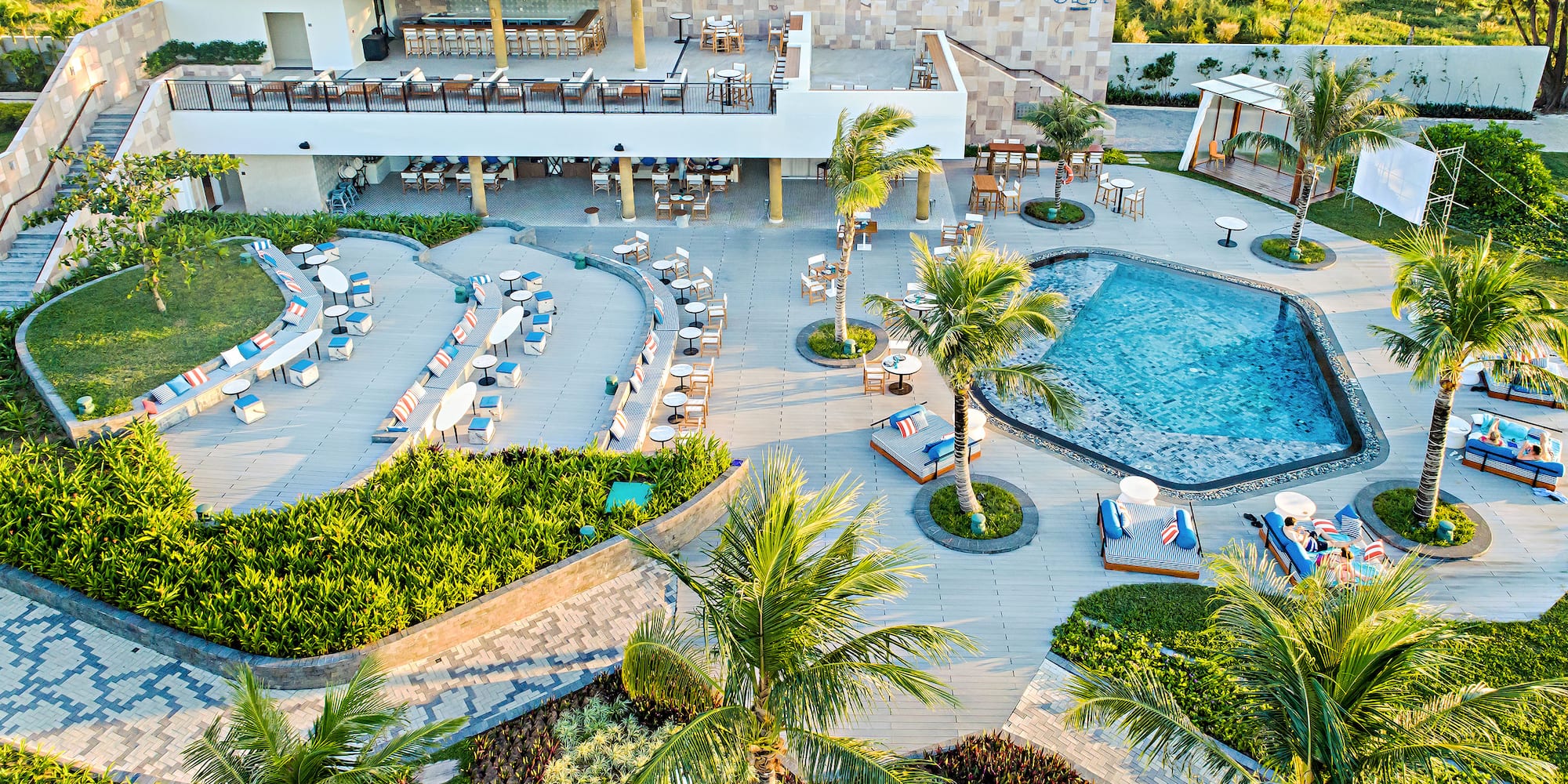 a pool and palm trees with chairs and tables