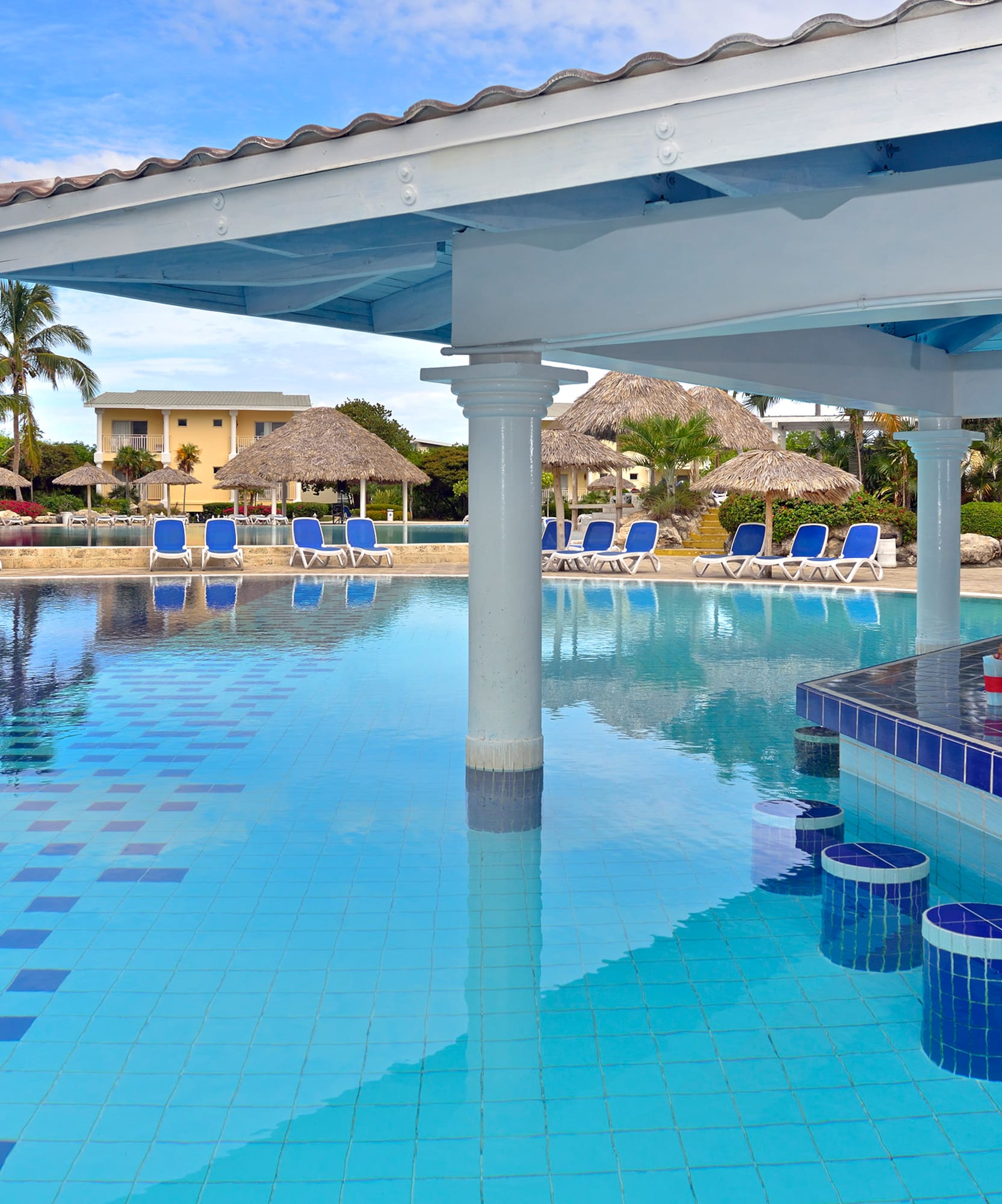 a pool with a bar and chairs
