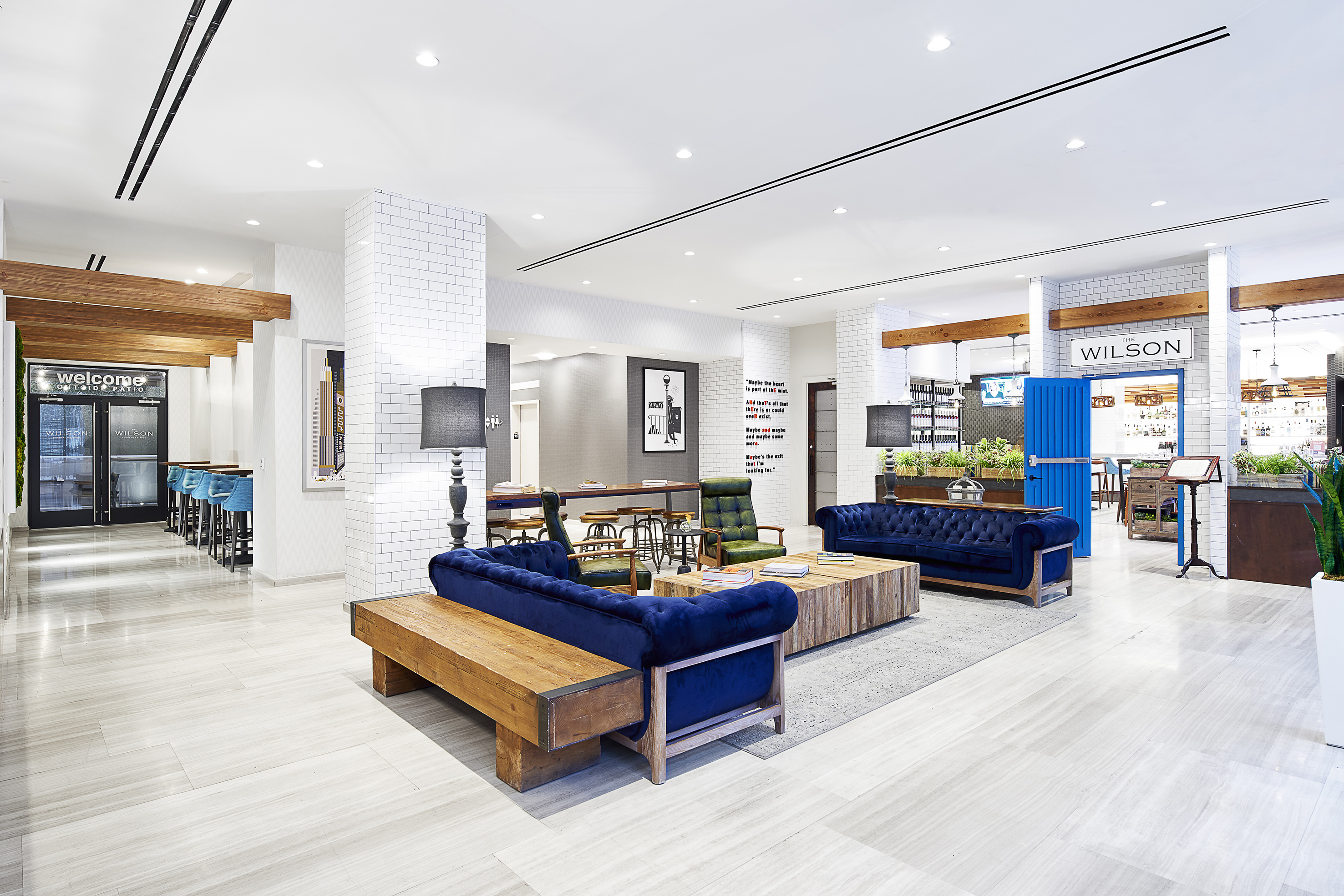 a room with blue couches and wood tables