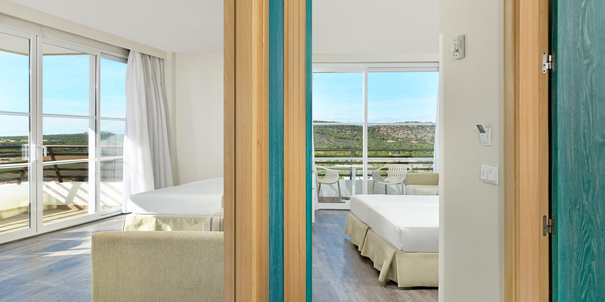 a room with two beds and a view of the landscape