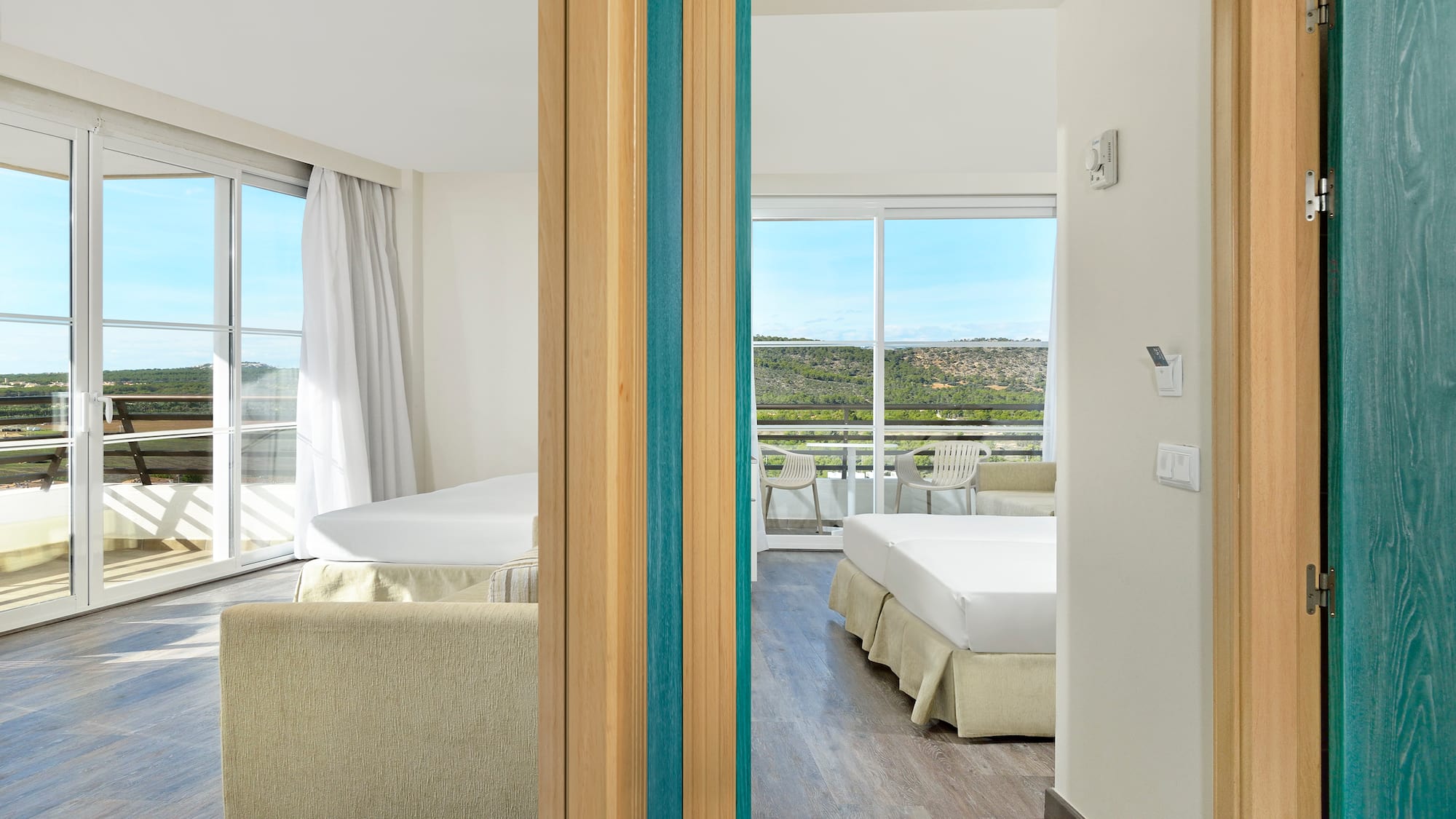 a room with two beds and a view of the landscape