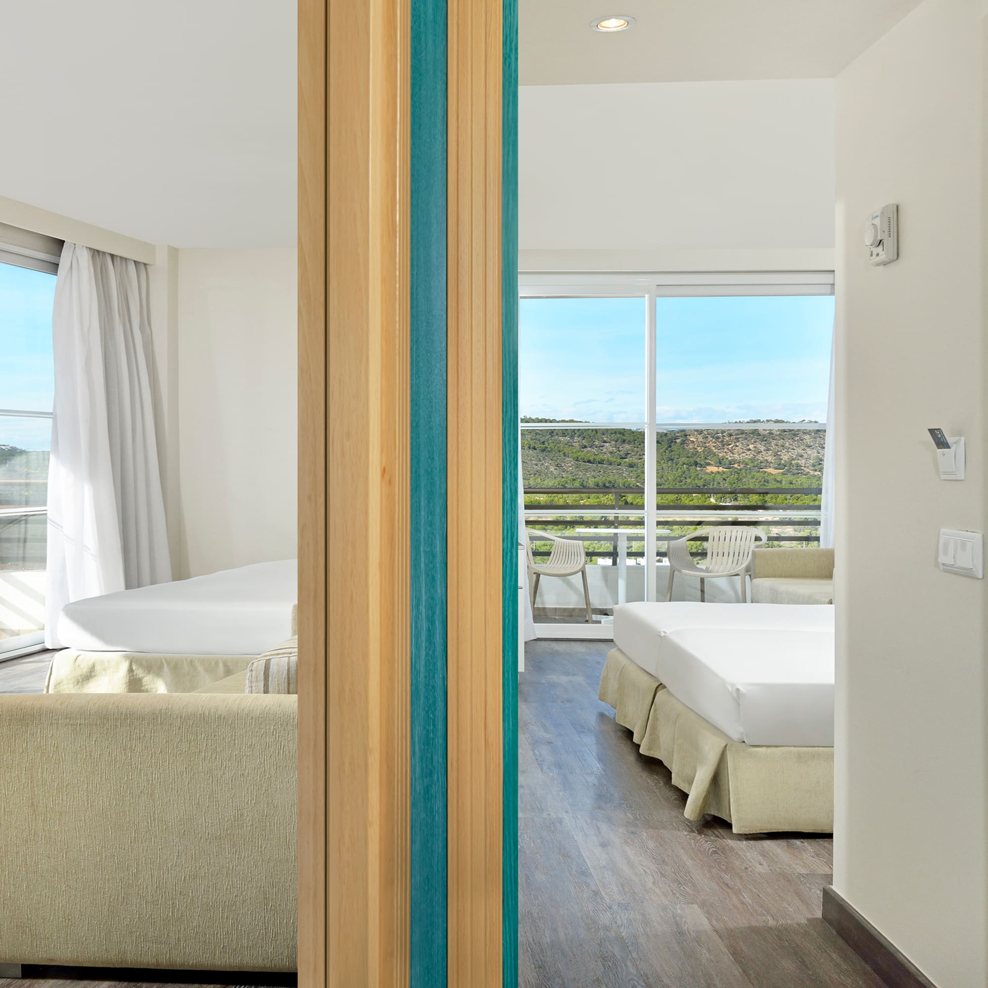 a room with two beds and a view of the landscape