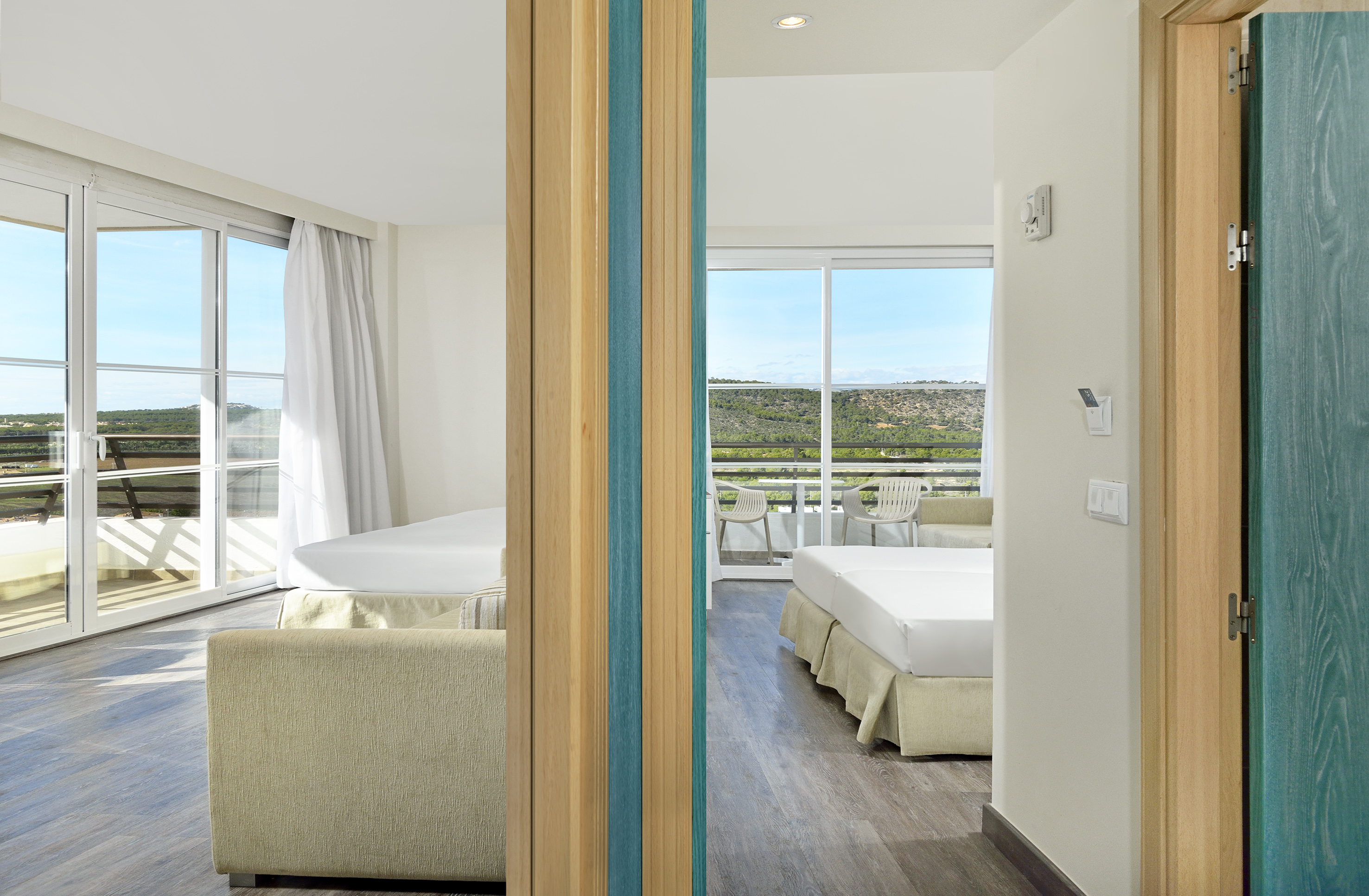 a room with two beds and a view of the landscape